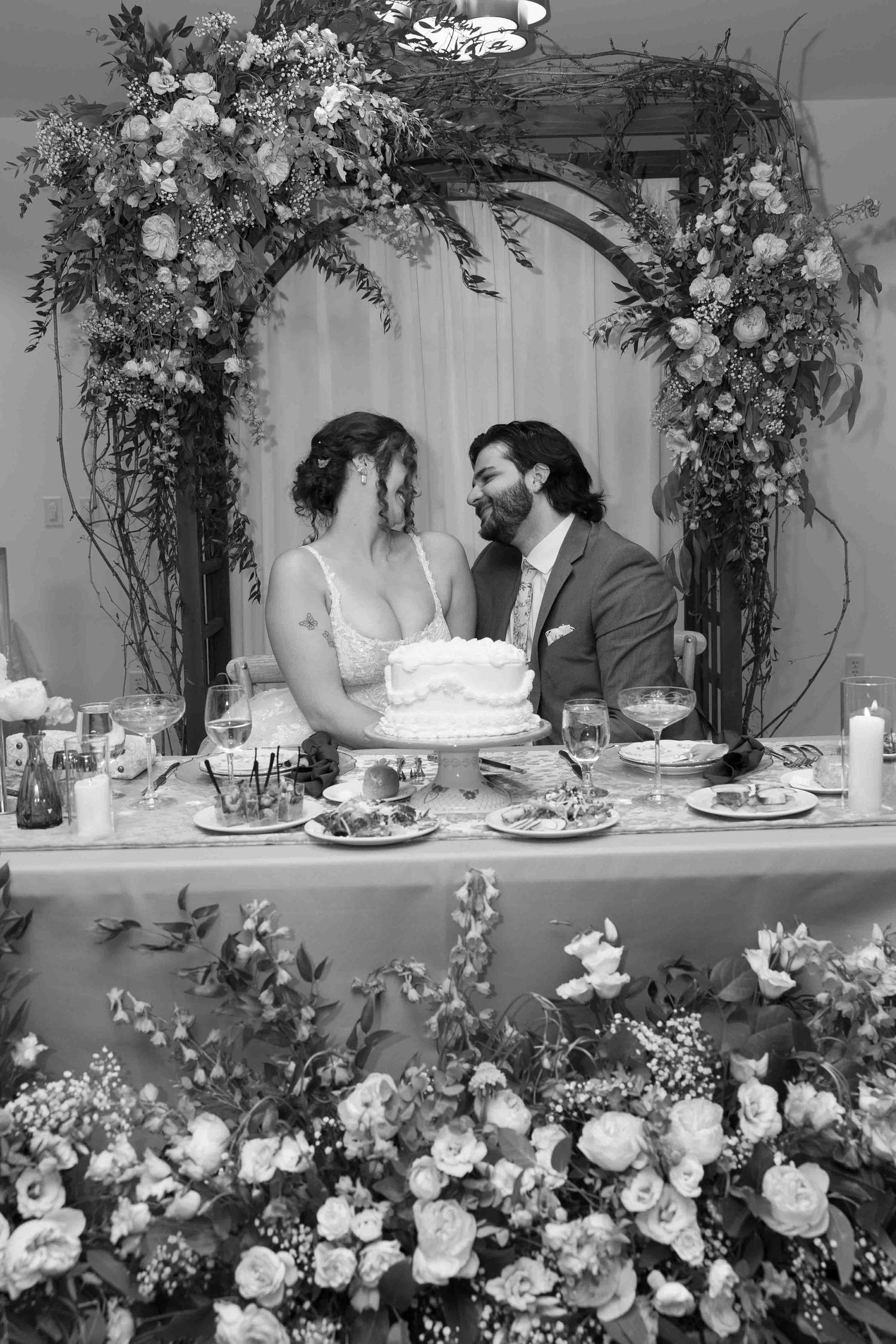 Wedding reception table with romantic floral arch and soft lighting.