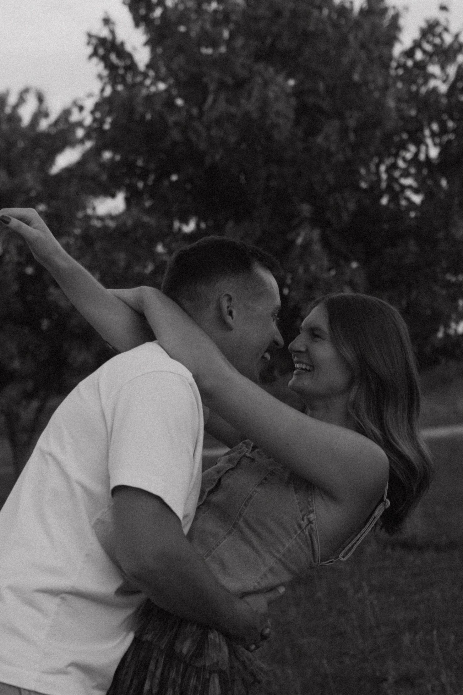 A romantic moment captured at dusk in a natural outdoor setting.