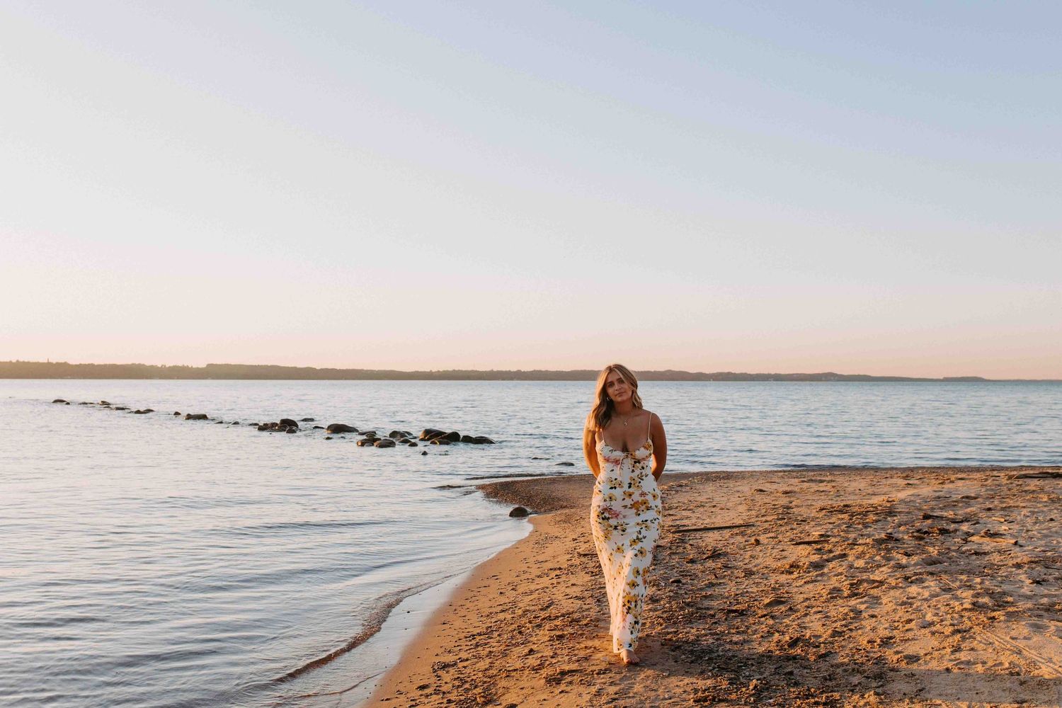 A peaceful beach landscape with calm waters and soft morning light.