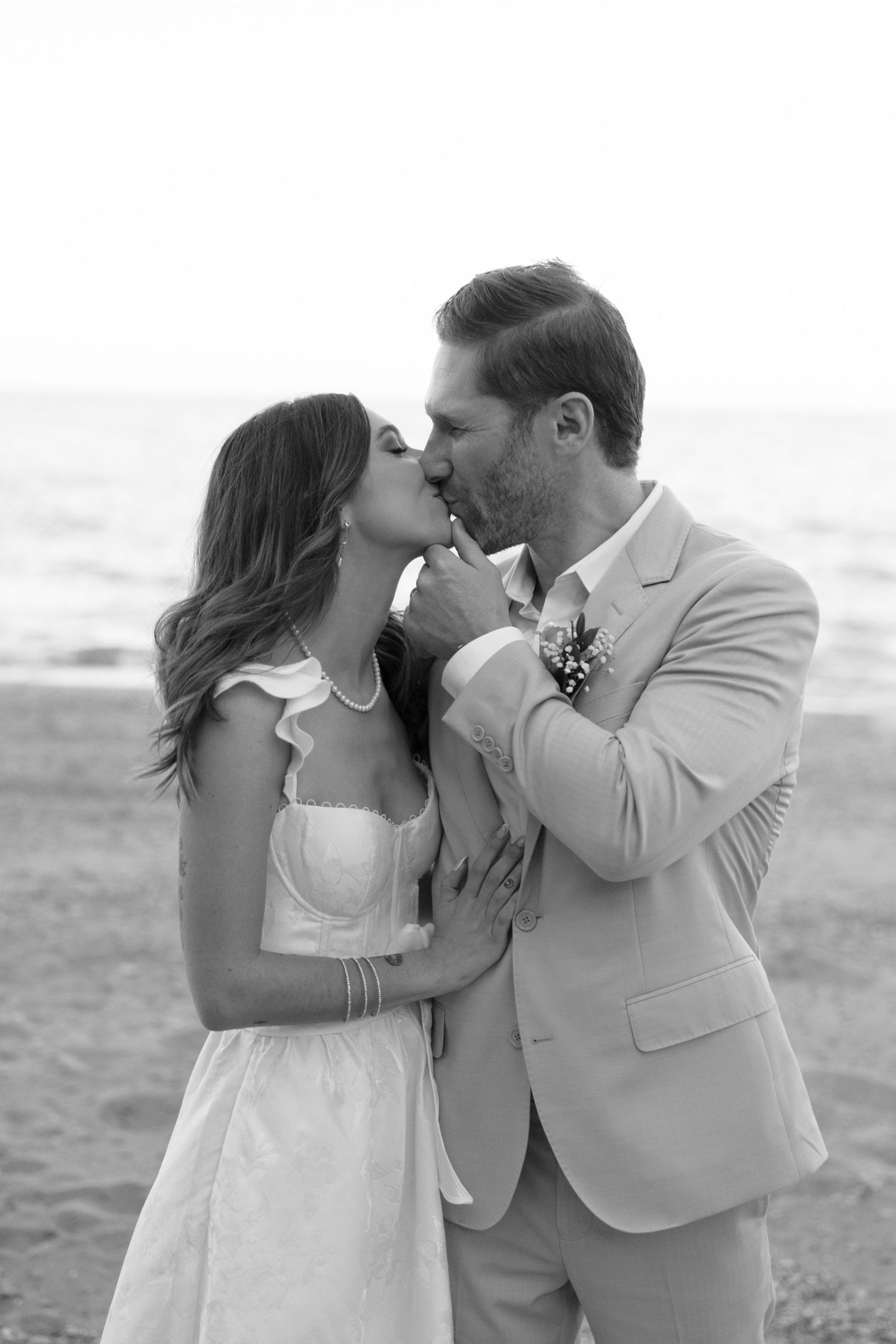 Intimate black and white beach wedding portraits showing tender moments between newlyweds.