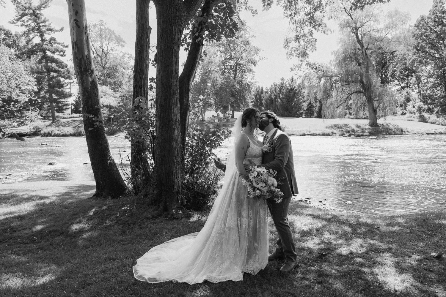 Black and white wedding photos captured in a serene outdoor setting with natural lighting.