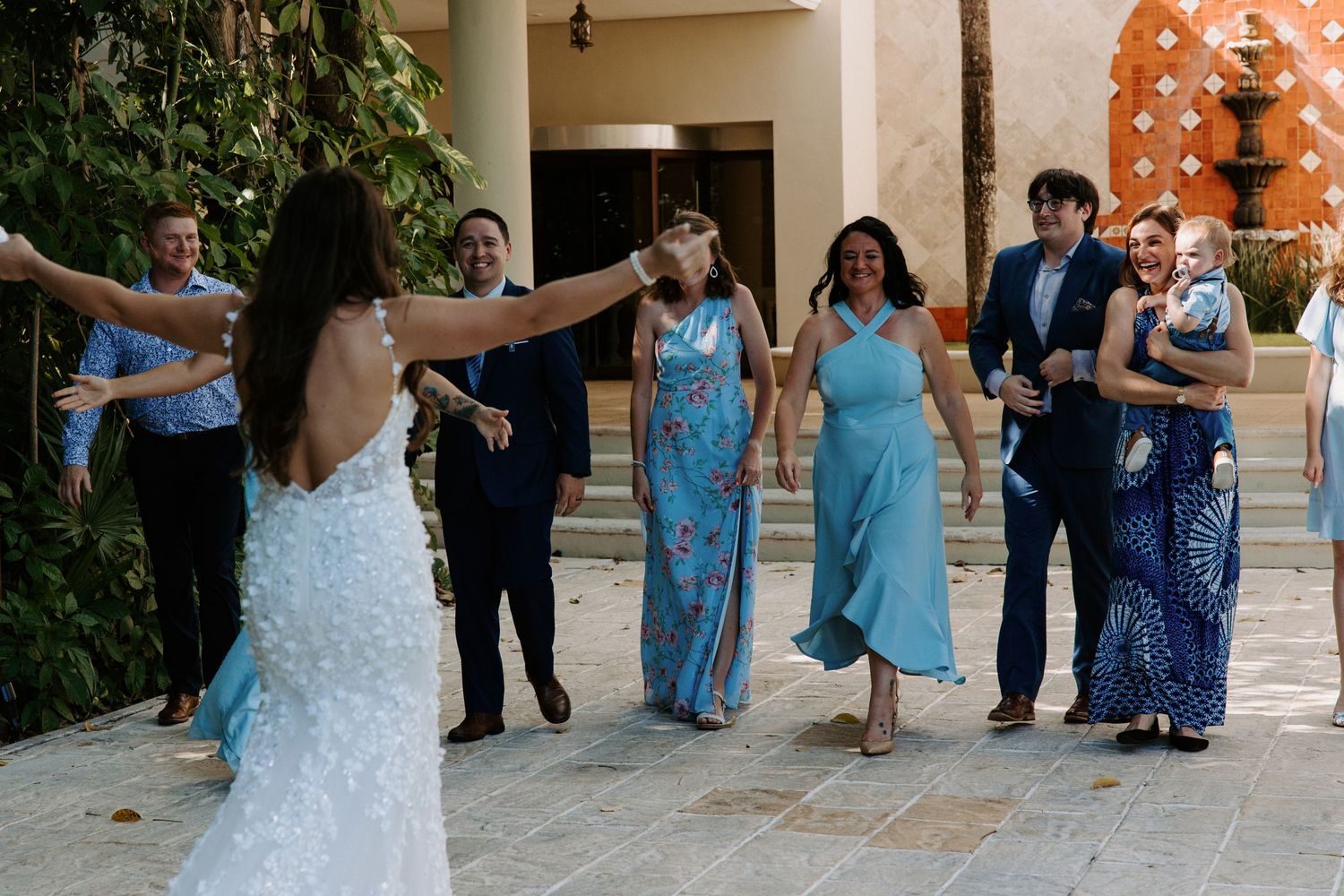 Bridesmaids in light blue dresses celebrate on an outdoor terrace.