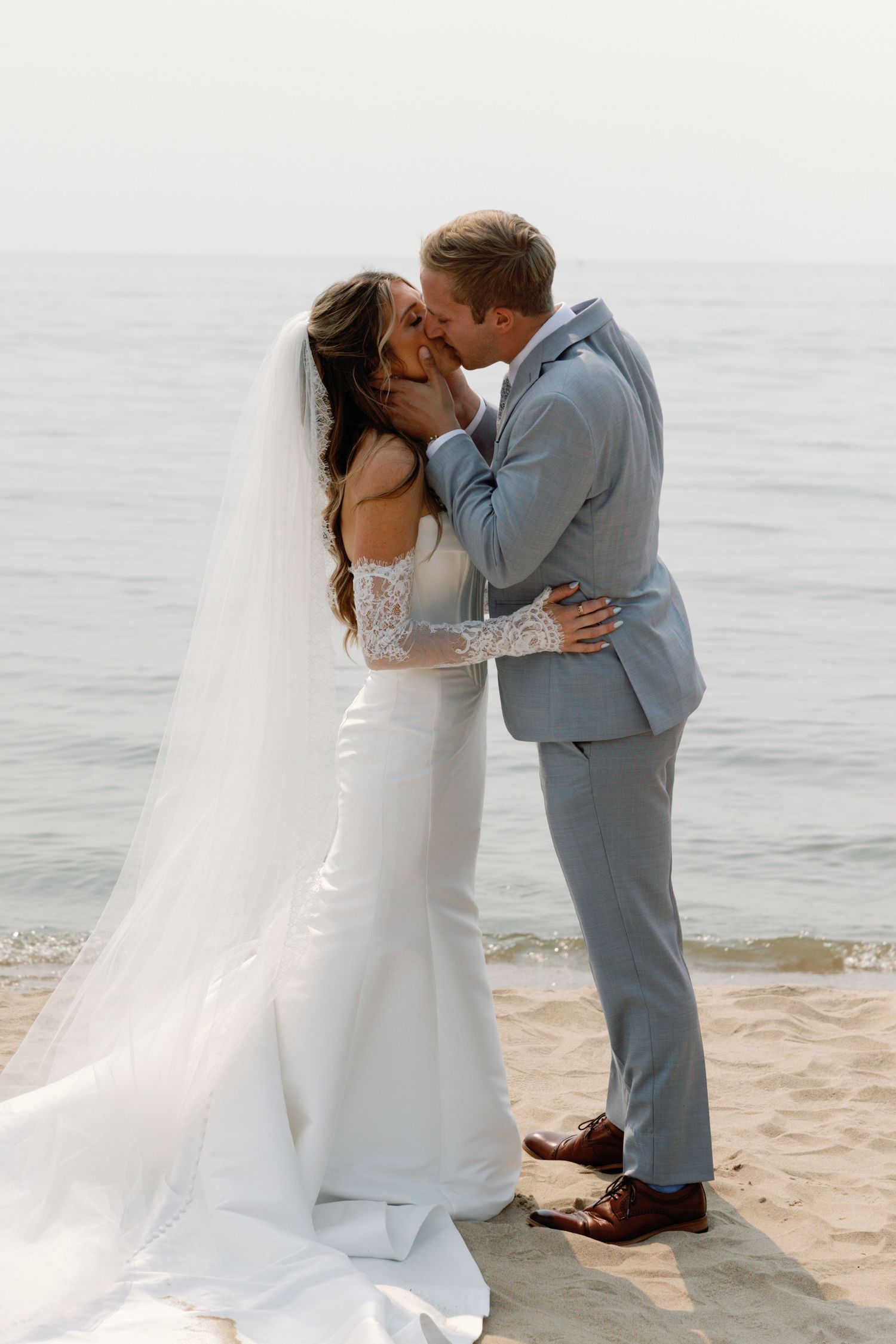 A couple shares intimate moments by the ocean during their beach wedding.