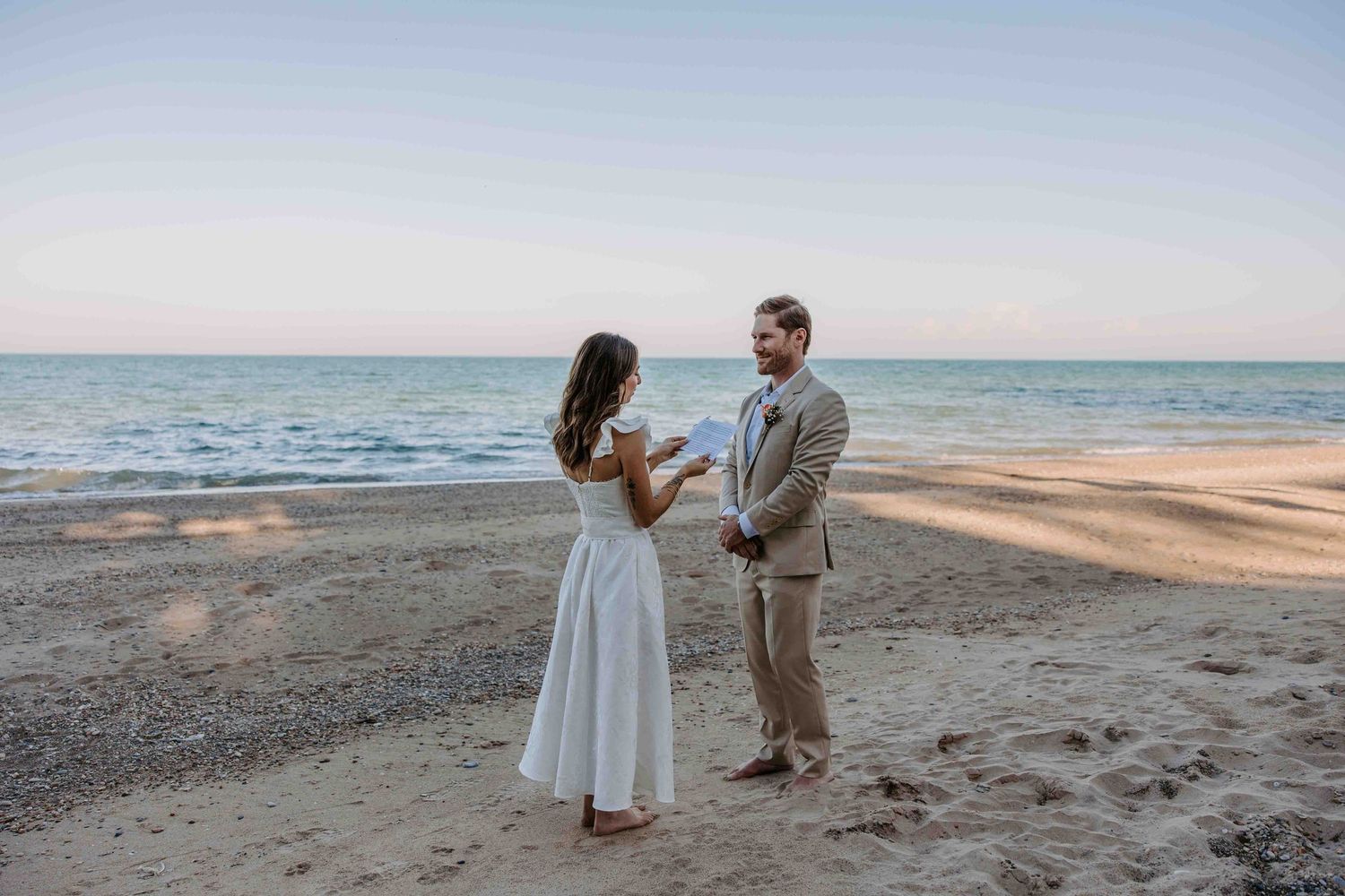 A seaside proposal sequence showing a couple on a sandy beach at dusk.