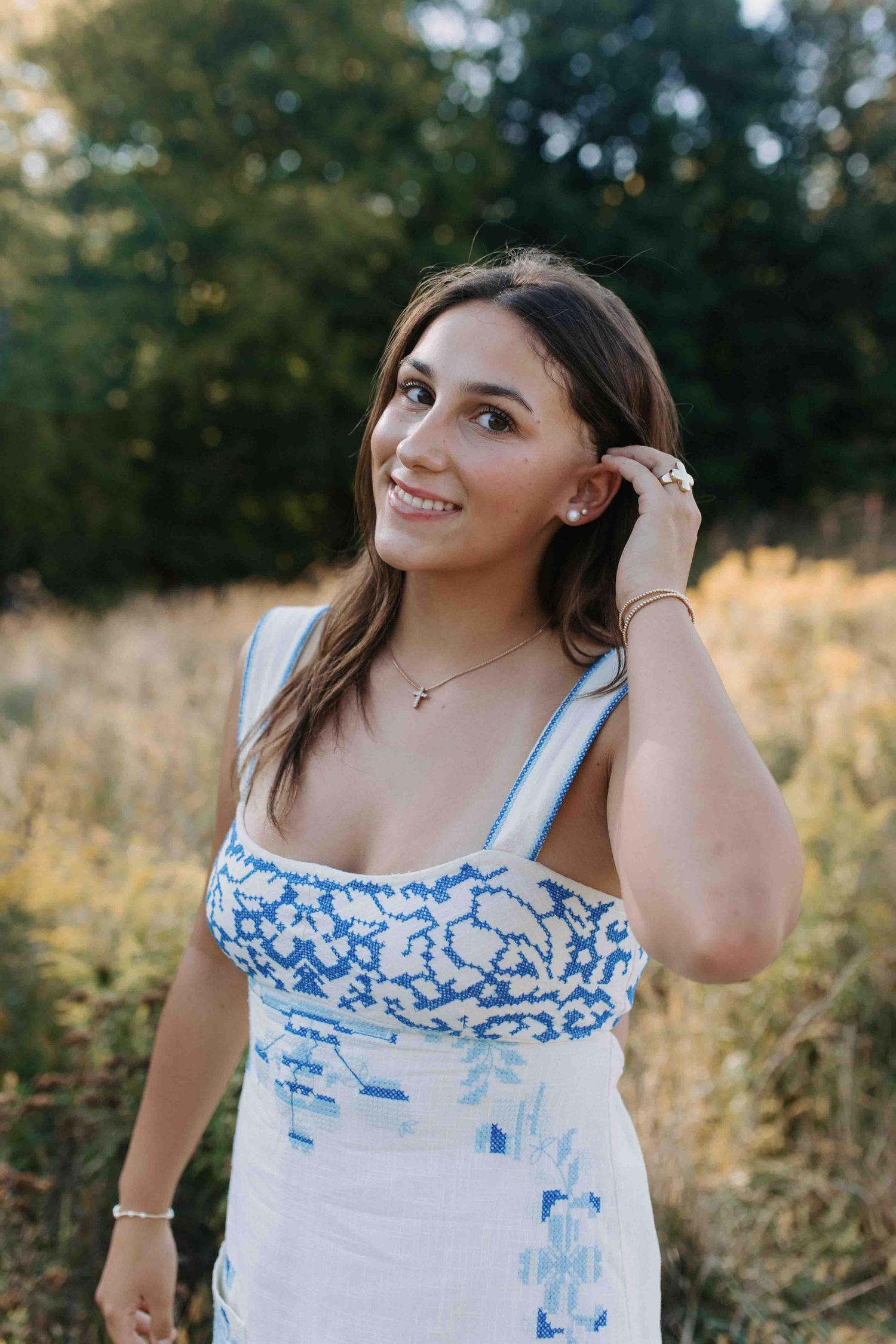 Summer portrait session featuring a blue and white dress against golden field backdrop.