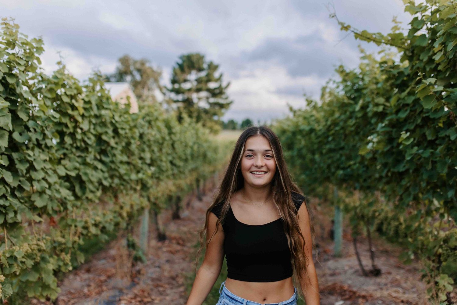 Summer portrait session among lush green vineyard rows.