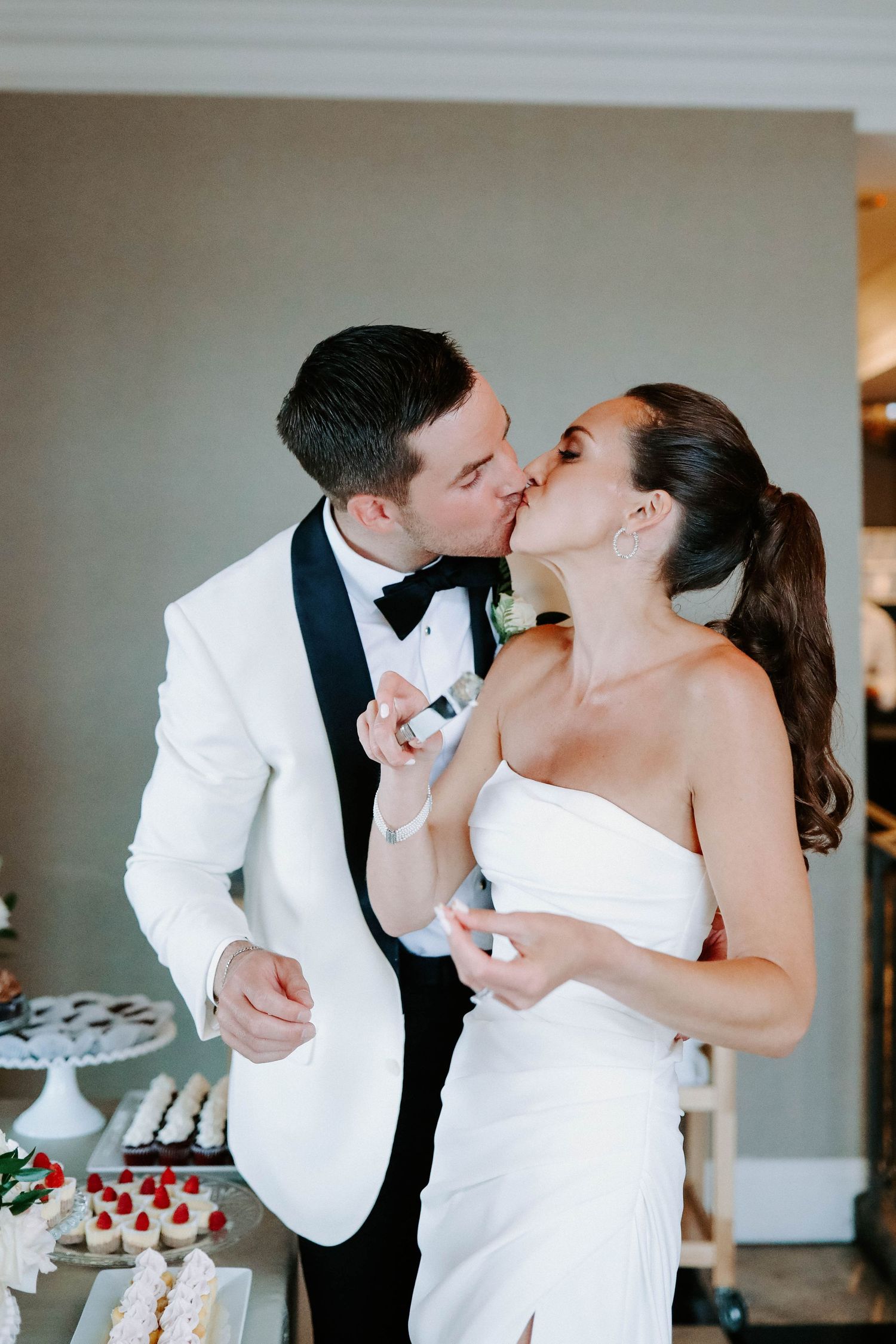 Newlyweds sharing cake during traditional wedding cake cutting ceremony.