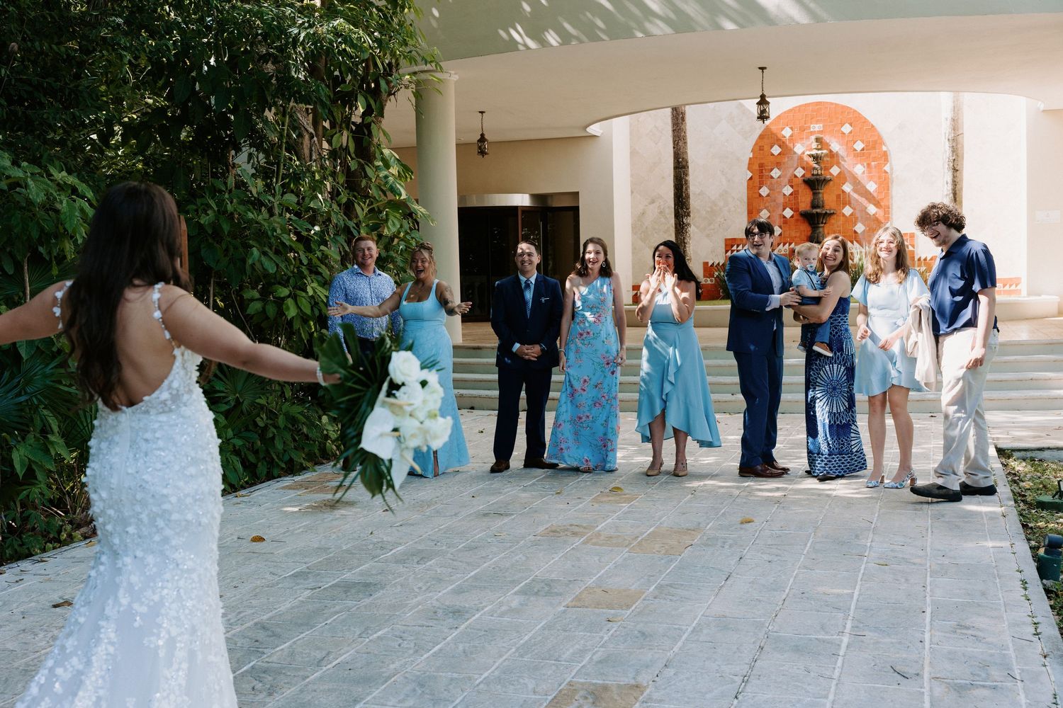 Wedding celebration scene on covered porch with guests in blue and formal attire.