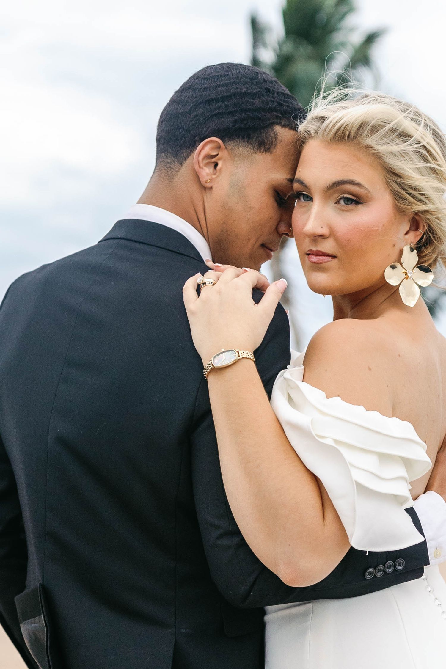 Romantic wedding portraits captured outdoors with tropical palm trees in background.