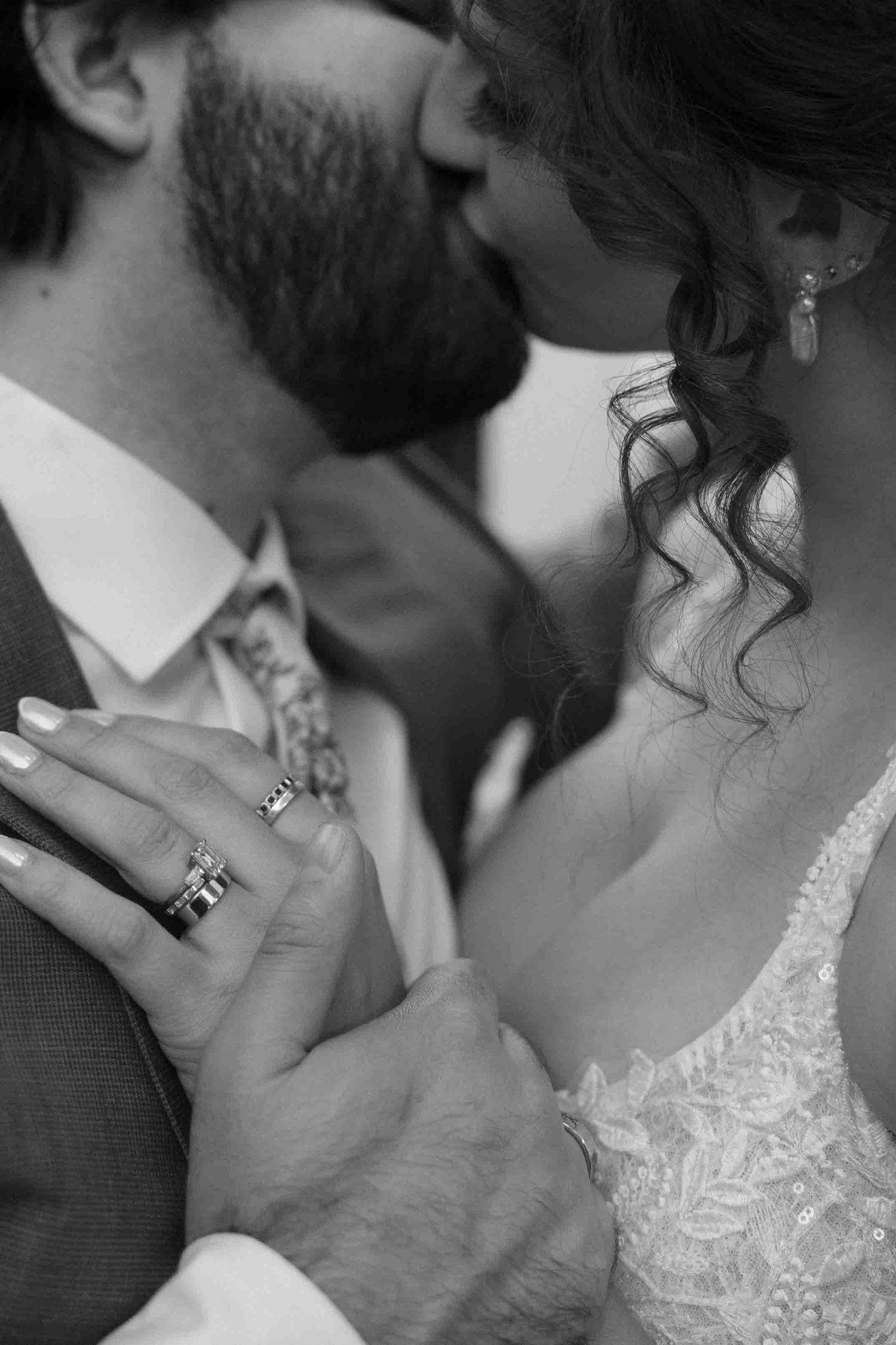An intimate black and white portrait of newlyweds sharing a tender moment.