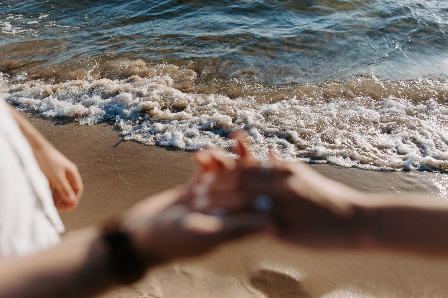 Close-up view of waves washing up on a sandy beach.
