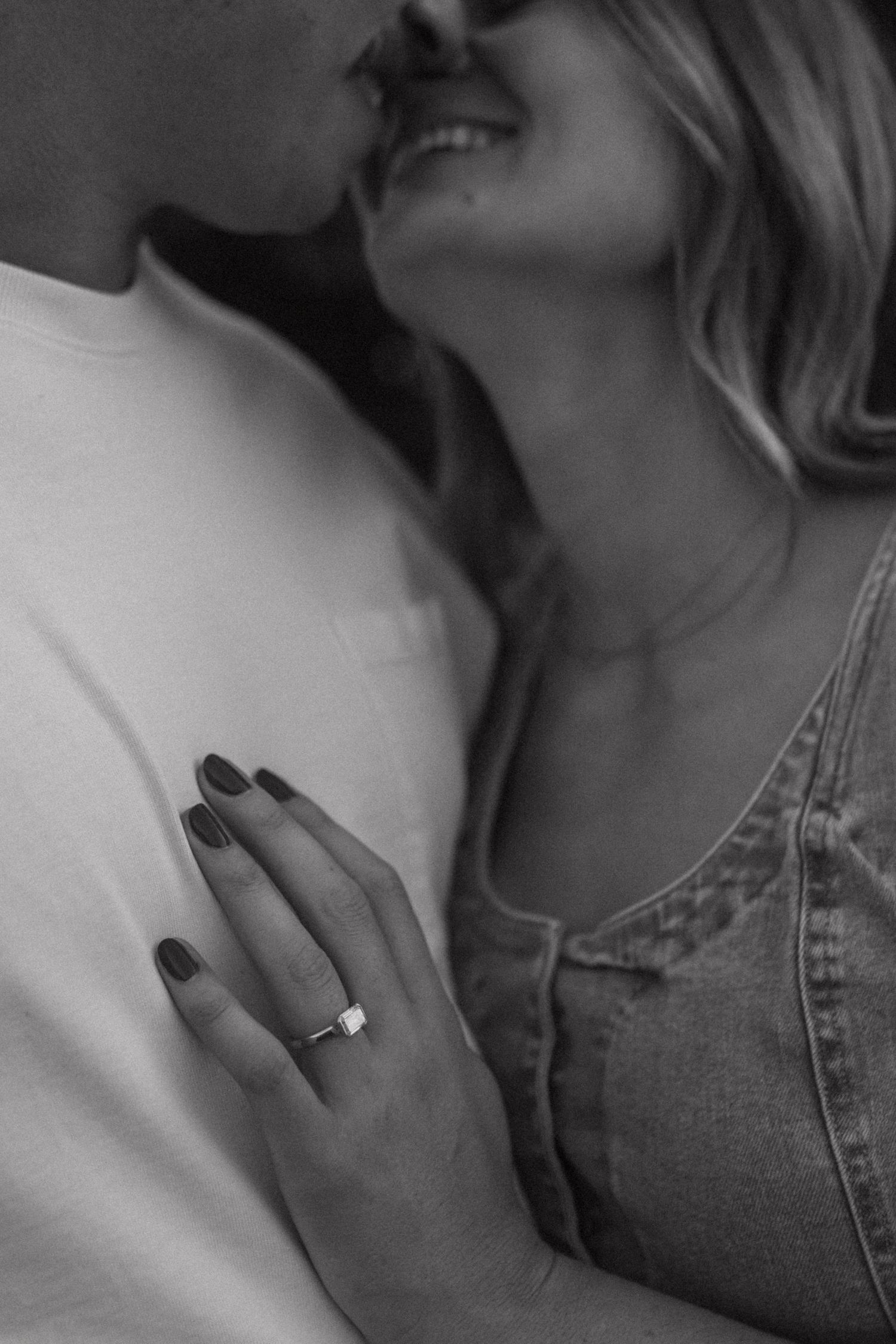 Close-up black and white shot showing a sparkling engagement ring.