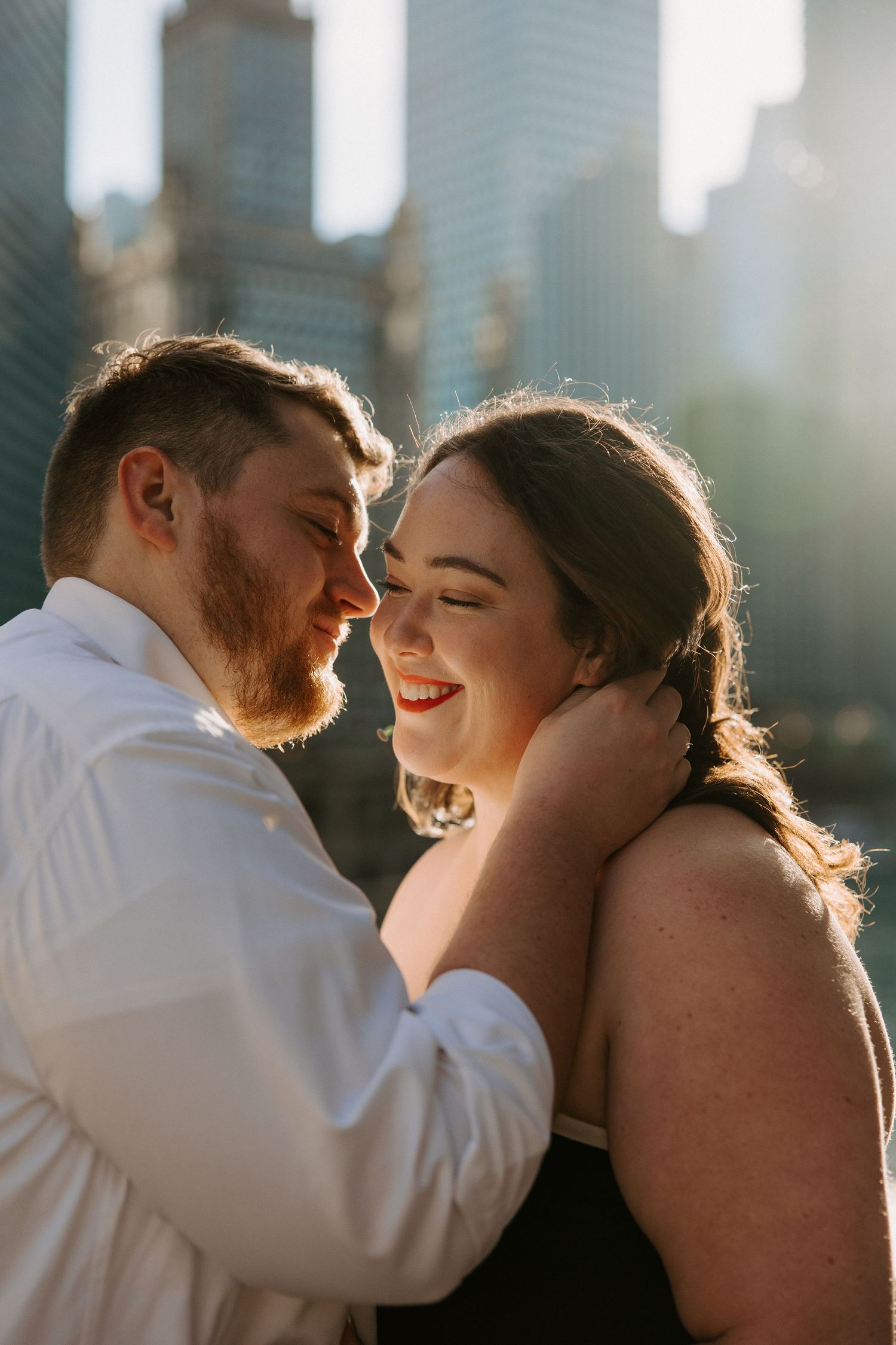 A romantic moment captured with sunlit city architecture in the background.