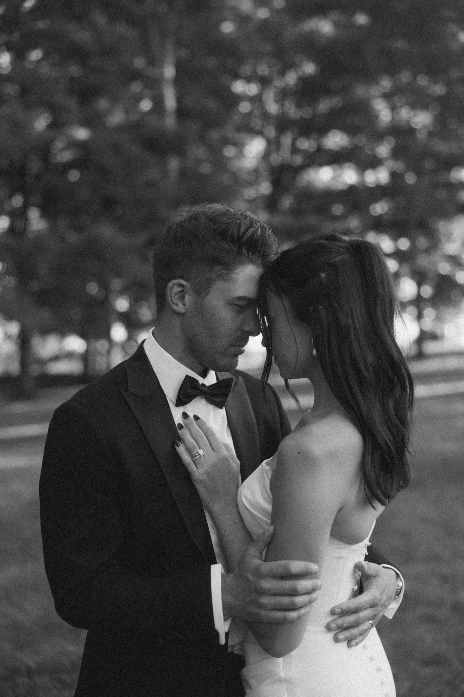 Romantic black and white wedding portraits showing intimate moments between newlyweds in an outdoor setting.