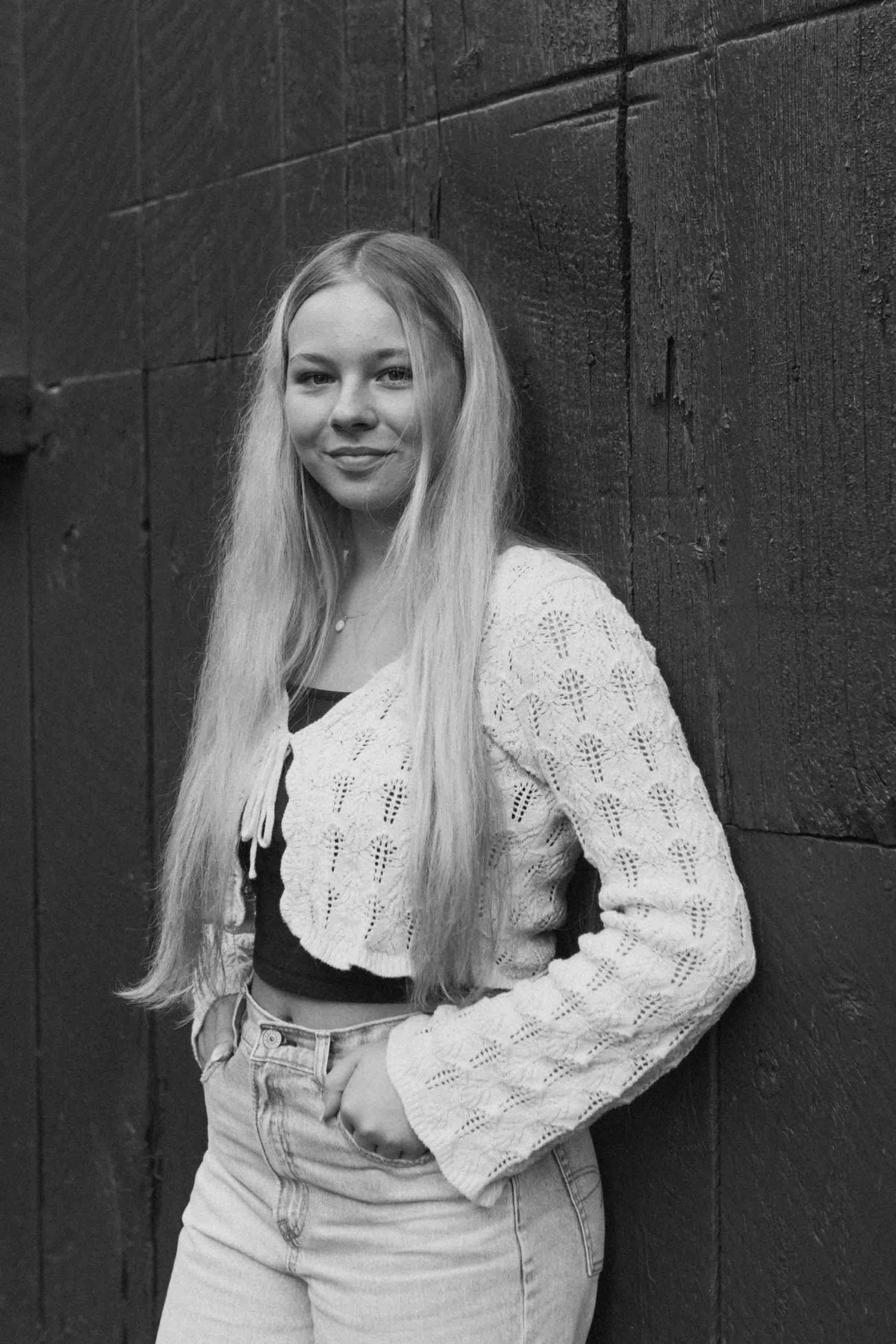 Black and white portraits against a dark textured wall showcasing casual autumn fashion.