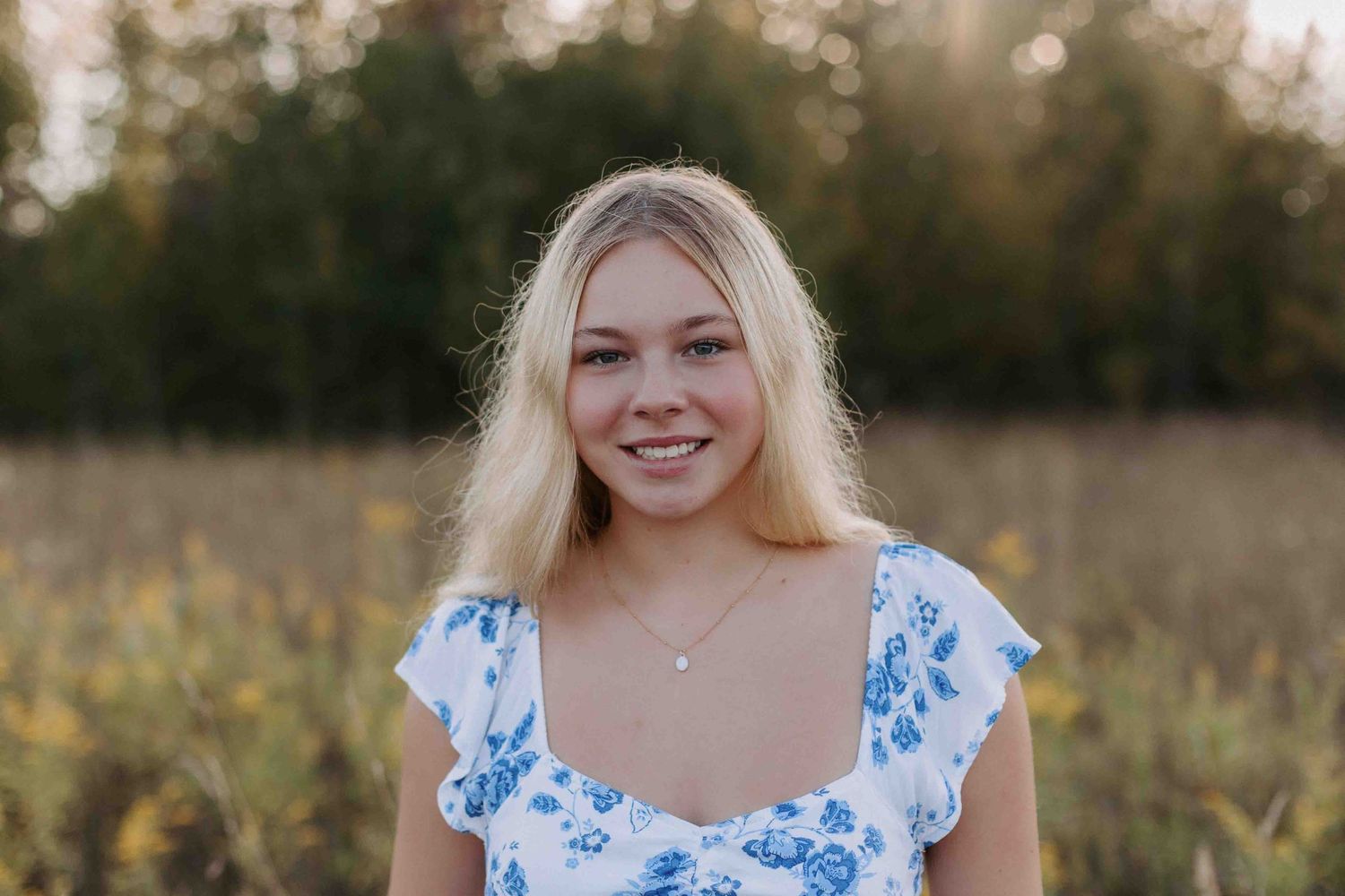 Casual outdoor portrait session in natural meadow setting.