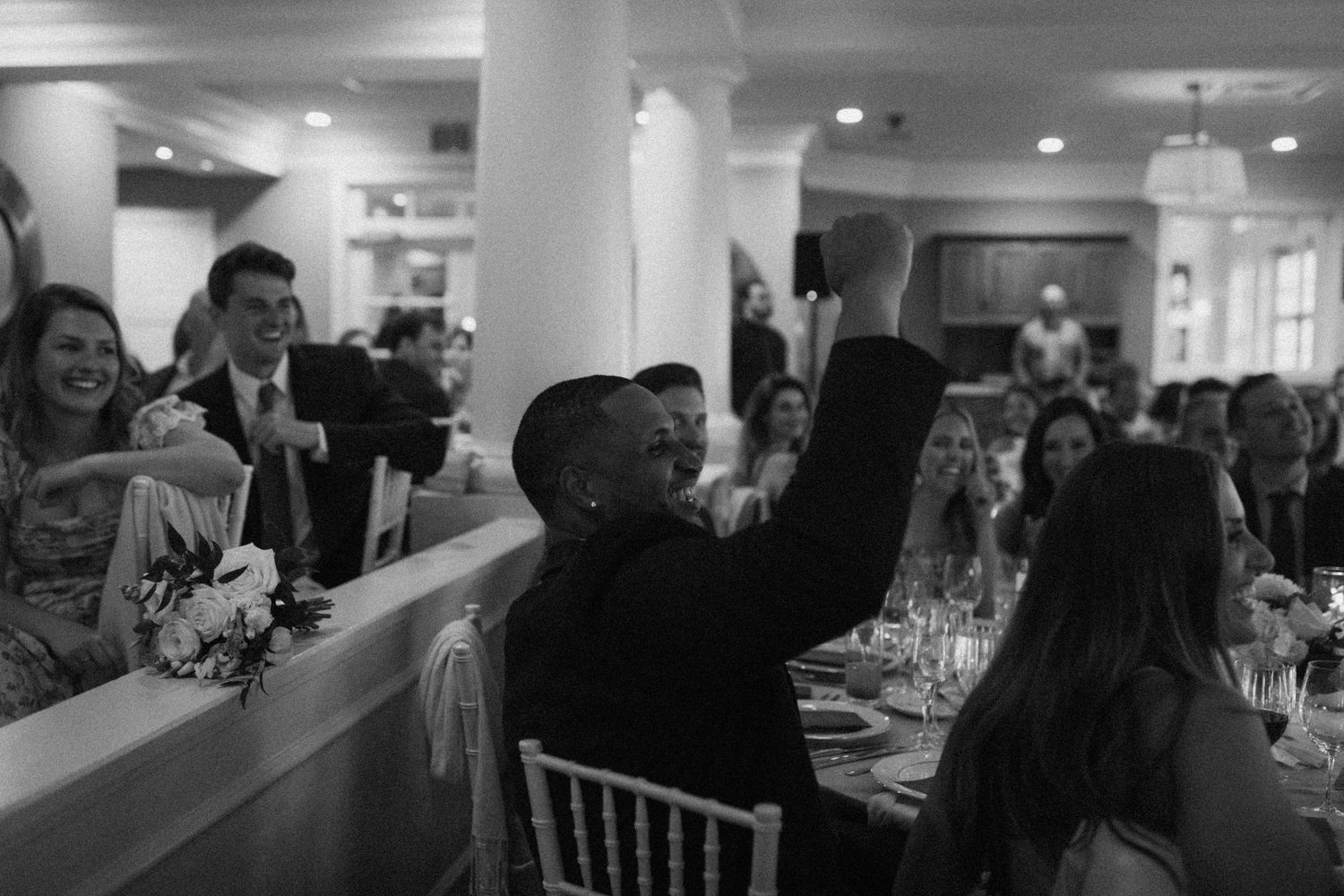 Wedding celebration in a bright venue with columns and large windows.