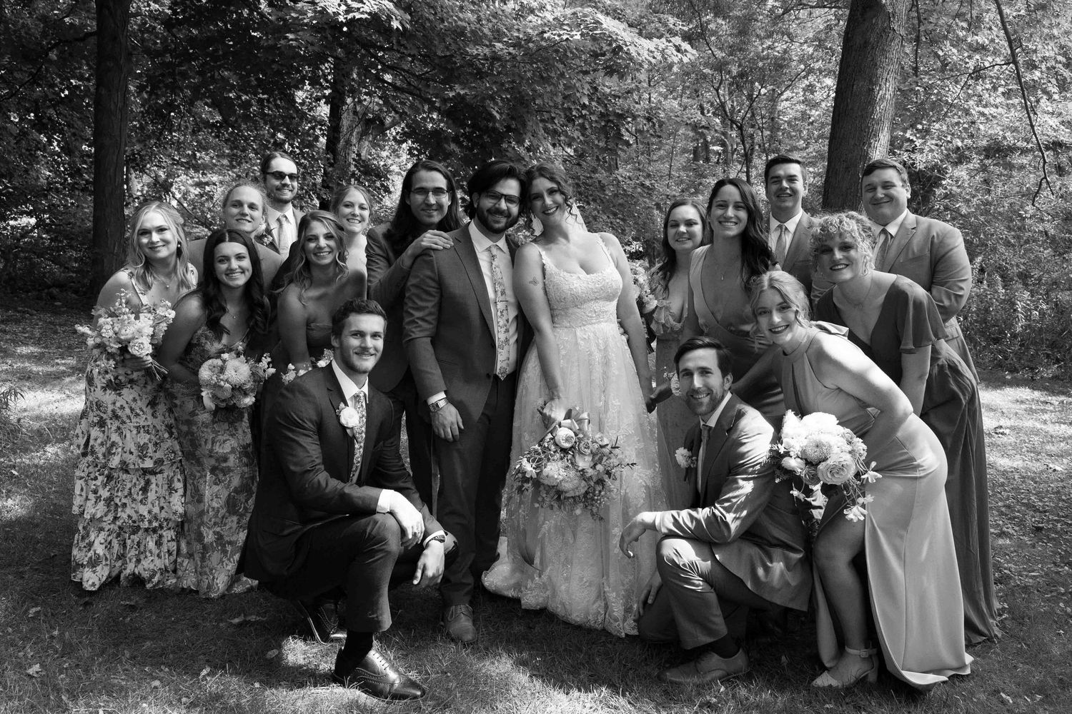 Wedding group photos taken in black and white with natural outdoor backdrop.