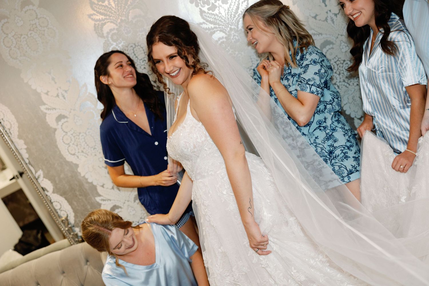 Wedding party members share joyful moments in light blue attire.