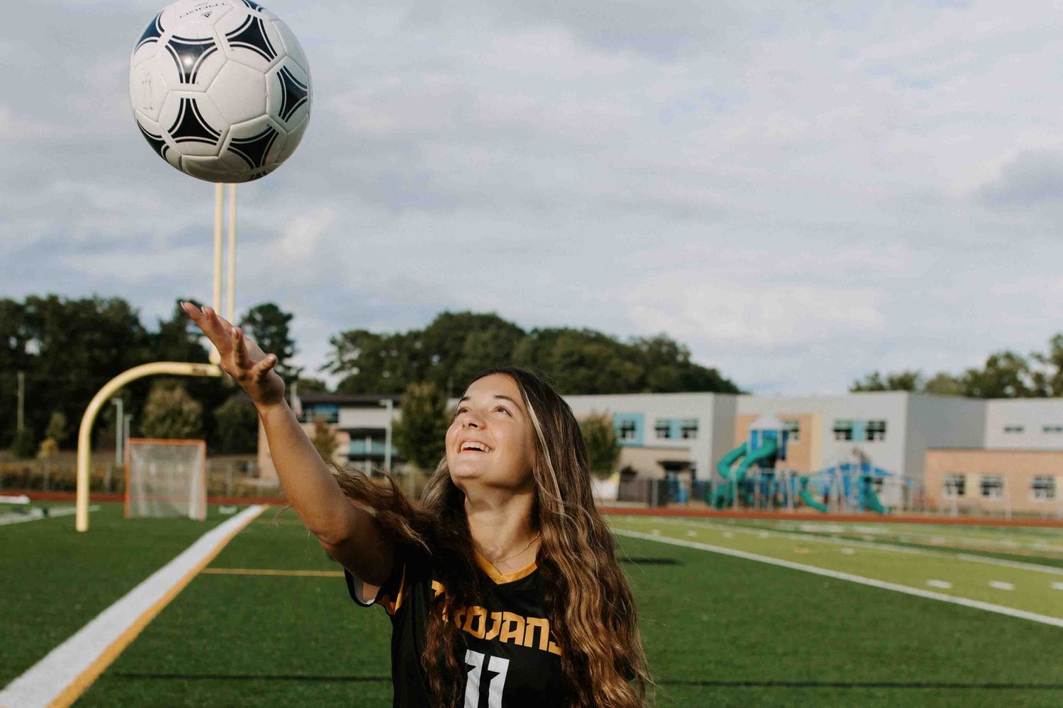 Soccer player practicing ball control with soccer ball on athletic field.