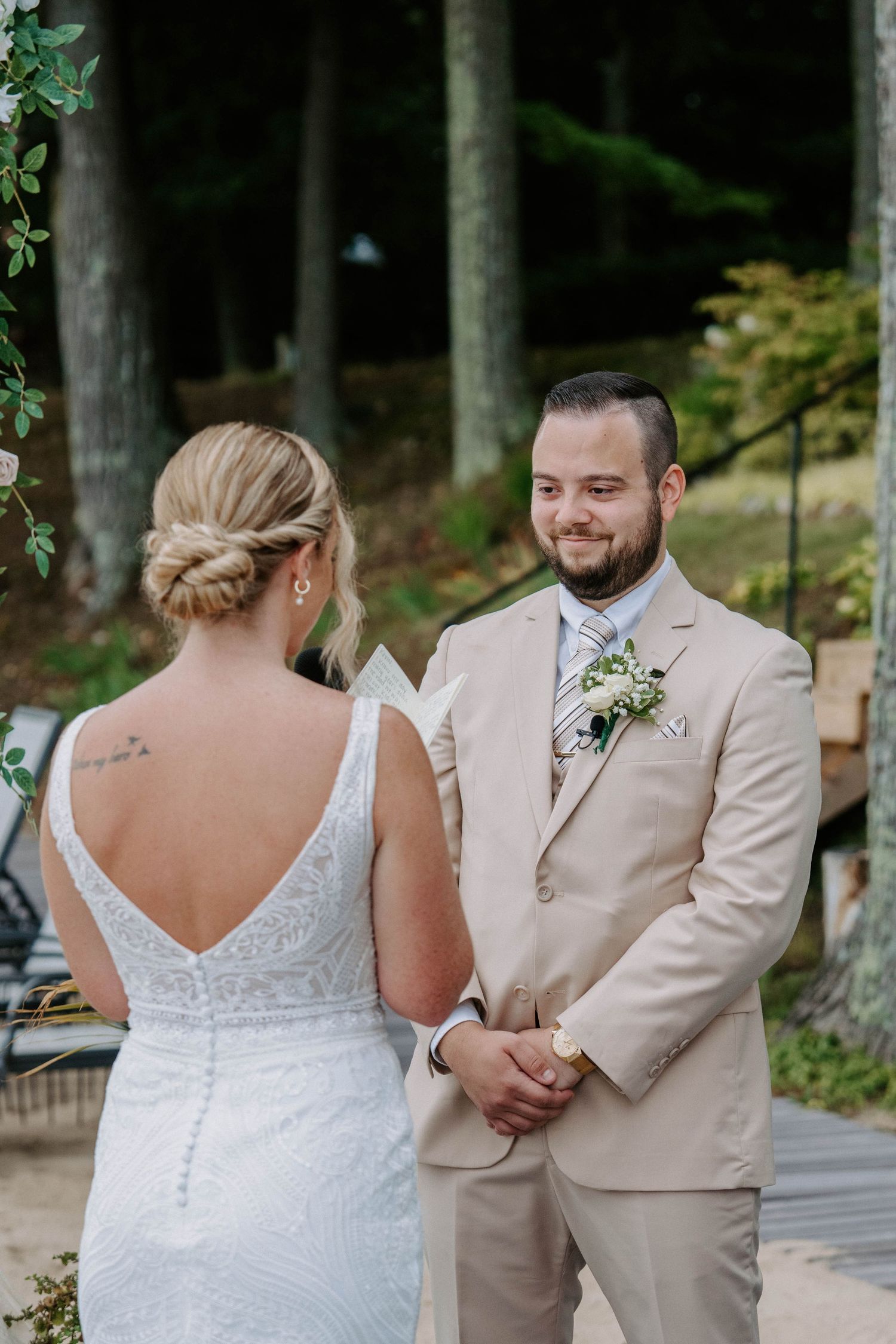 Wedding couple shares first look moments under covered walkway.