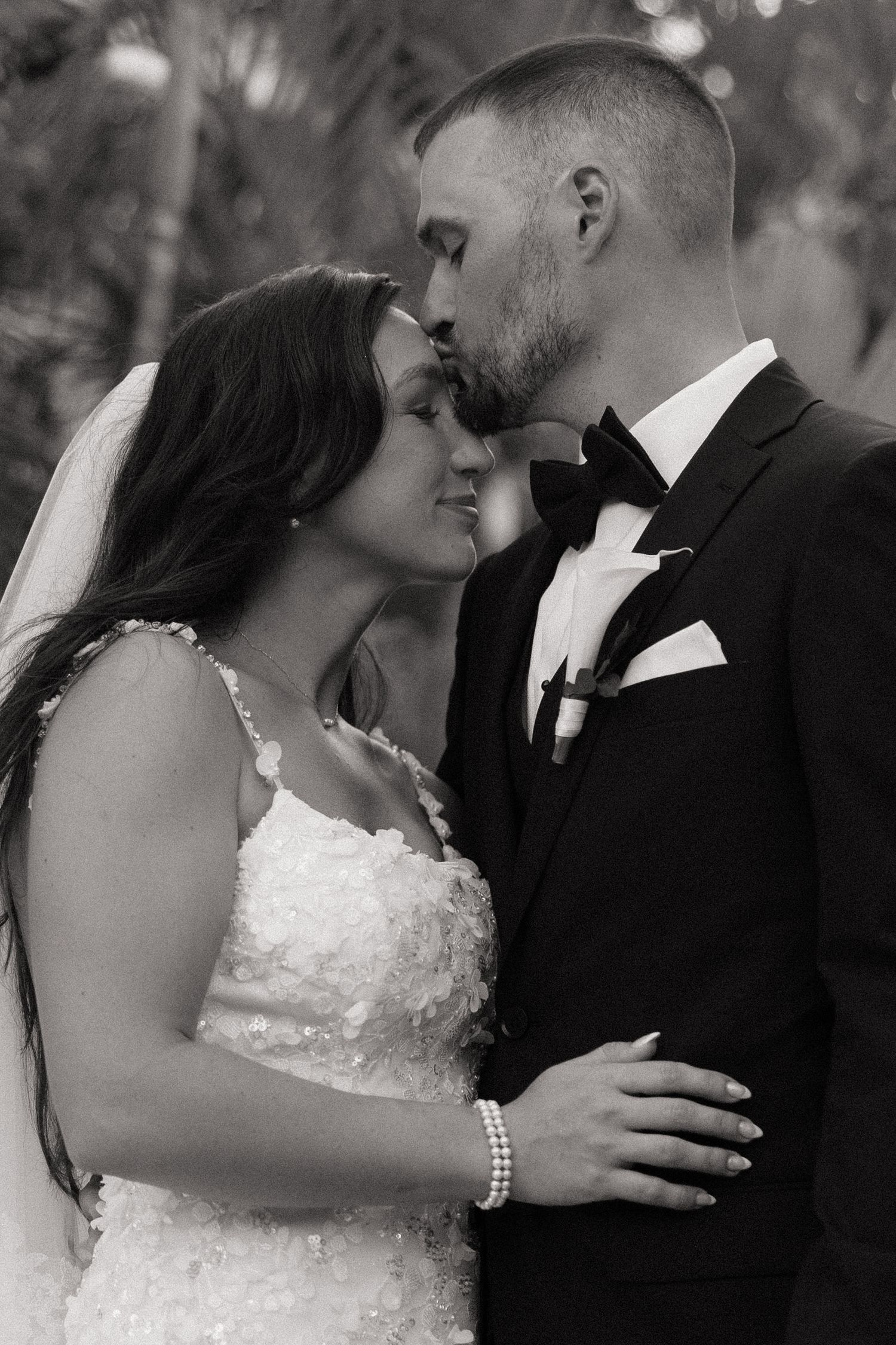 Romantic black and white portrait of newlyweds sharing an intimate moment.