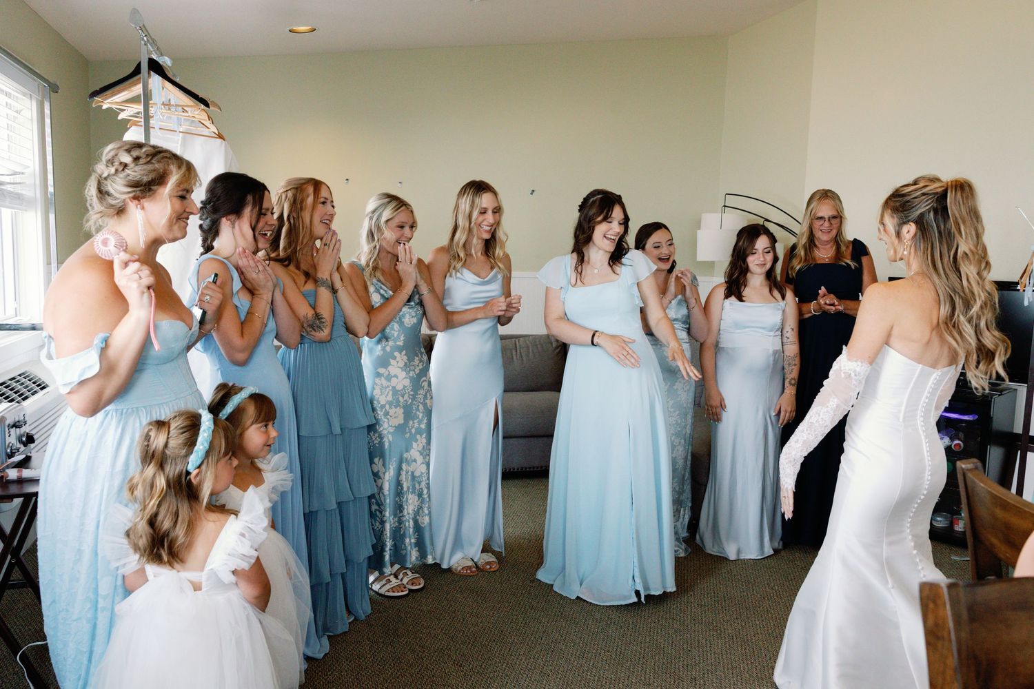 A bridal party in light blue dresses lines up for photos in an indoor venue.
