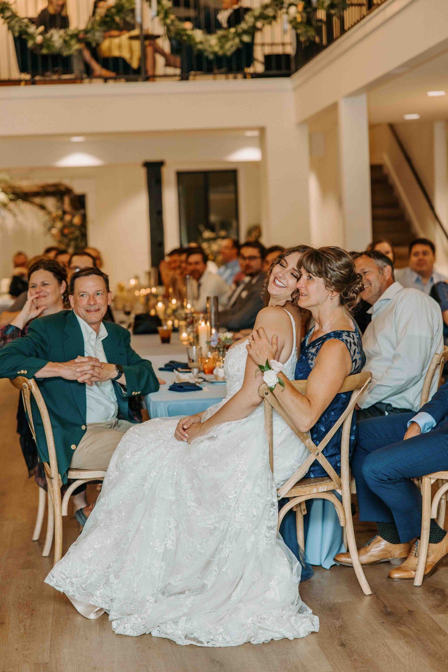 Guests in formal attire dance and celebrate at an elegant indoor wedding reception.