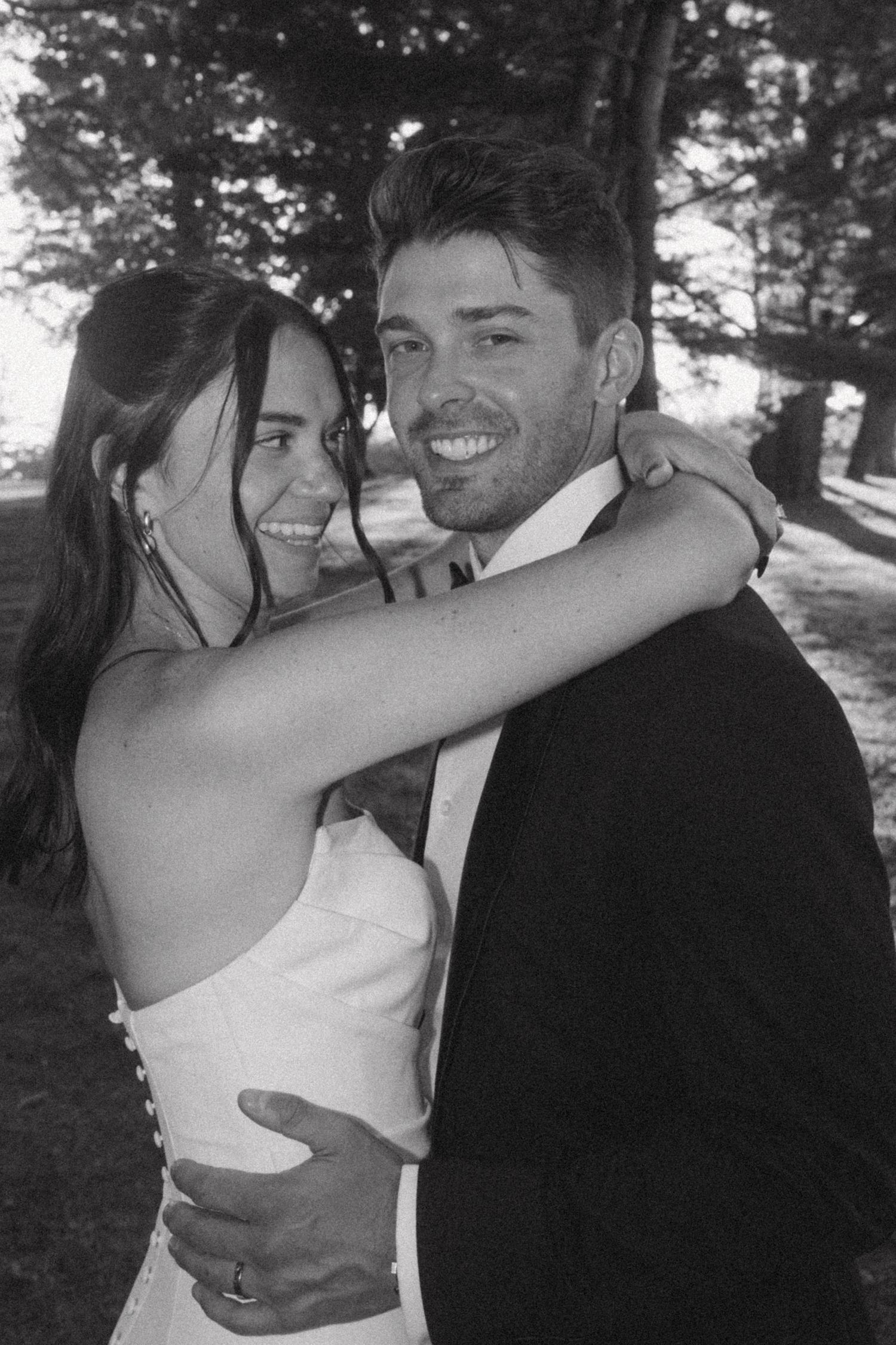 A romantic wedding couple shares intimate moments in a series of black and white outdoor portraits.