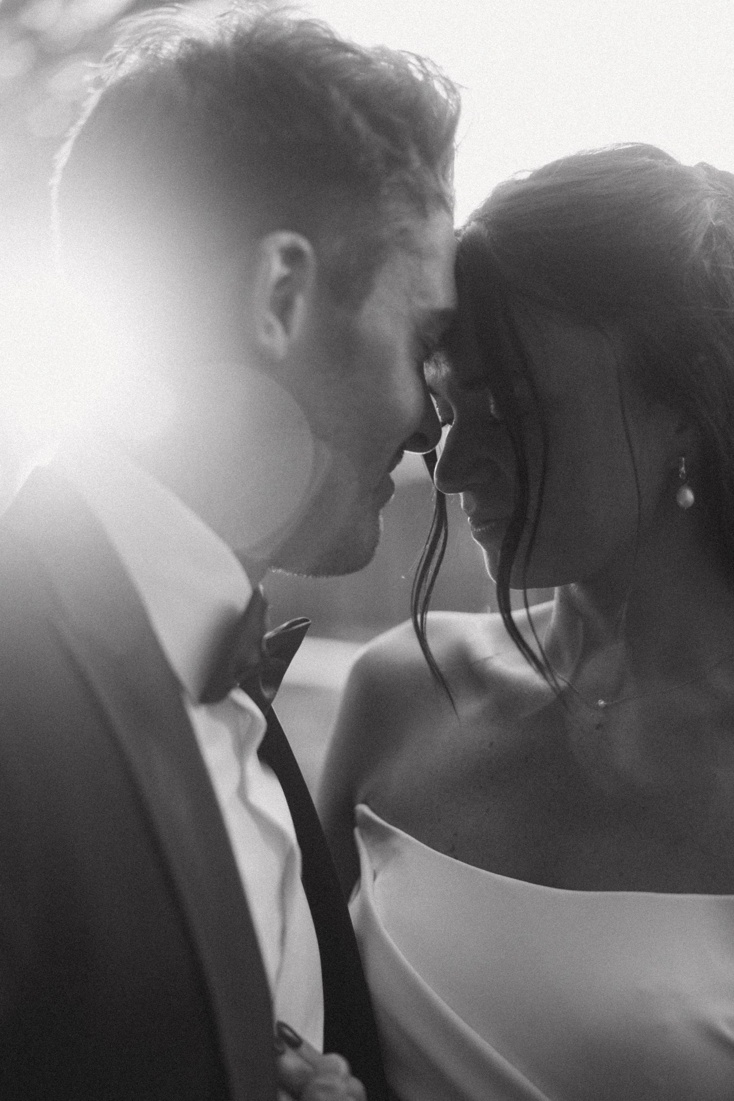 Black and white romantic portrait of newlyweds in soft lighting.