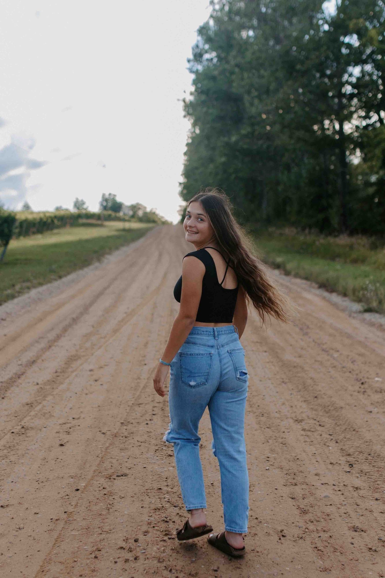 Two people walking and laughing together on a winding dirt road.