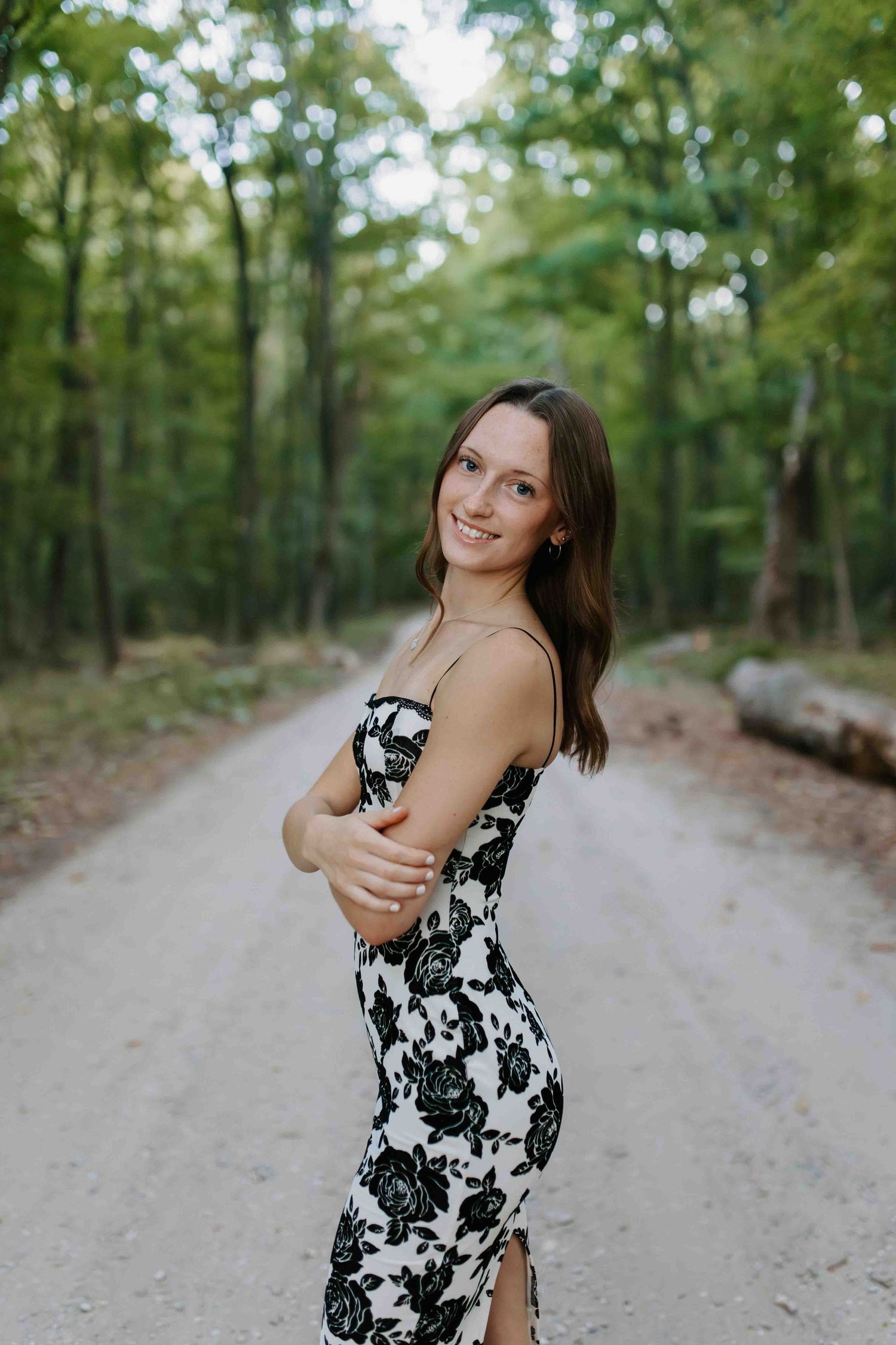 Playful poses on a forest path wearing a black and white floral summer dress.