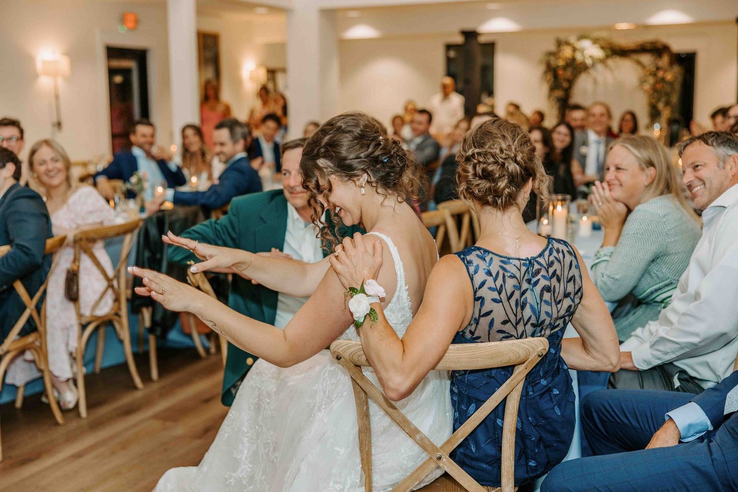 Wedding celebration with guests seated at tables watching dancers in a bright indoor venue.