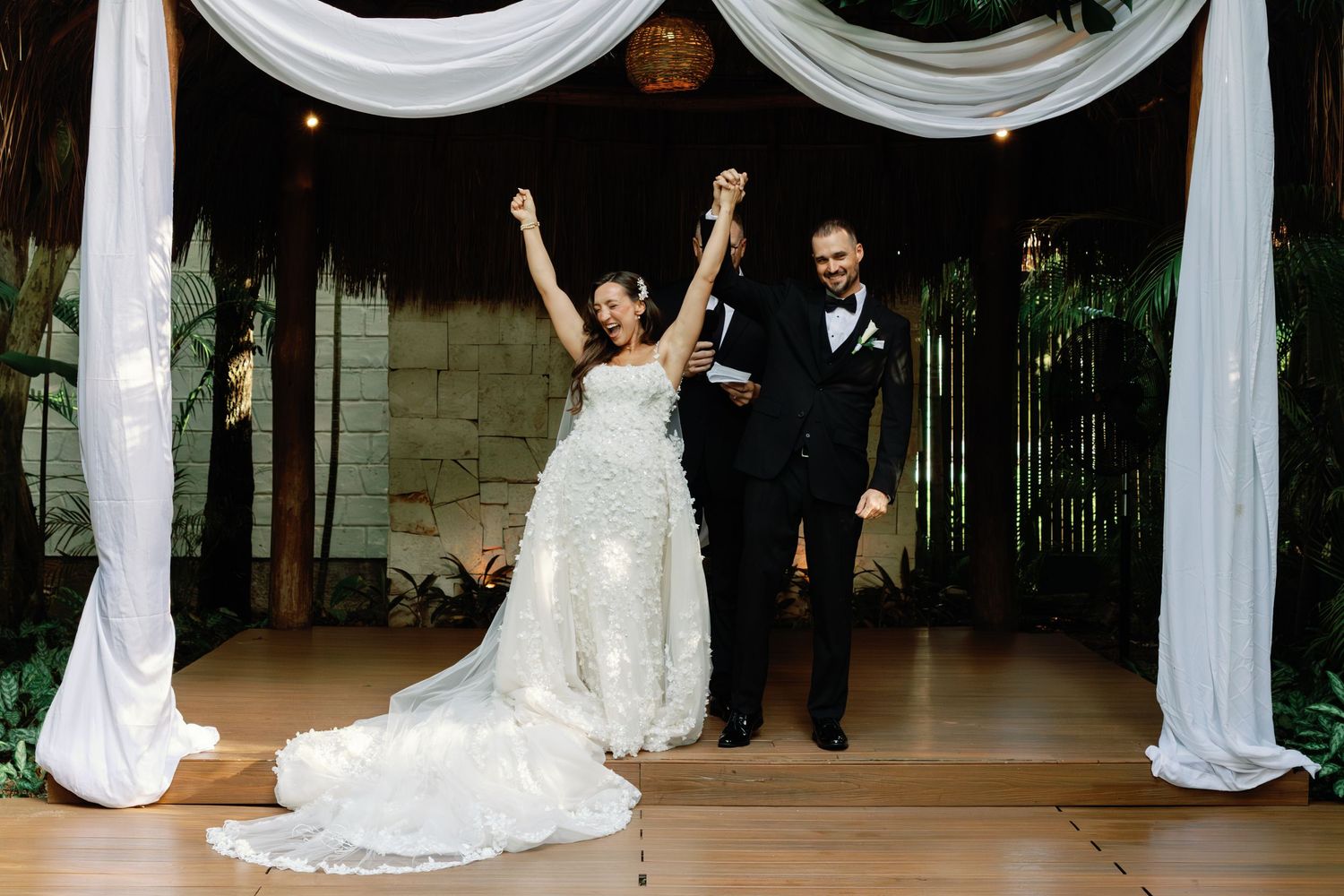Wedding ceremony setup with white fabric draping and chairs in an elegant indoor venue.