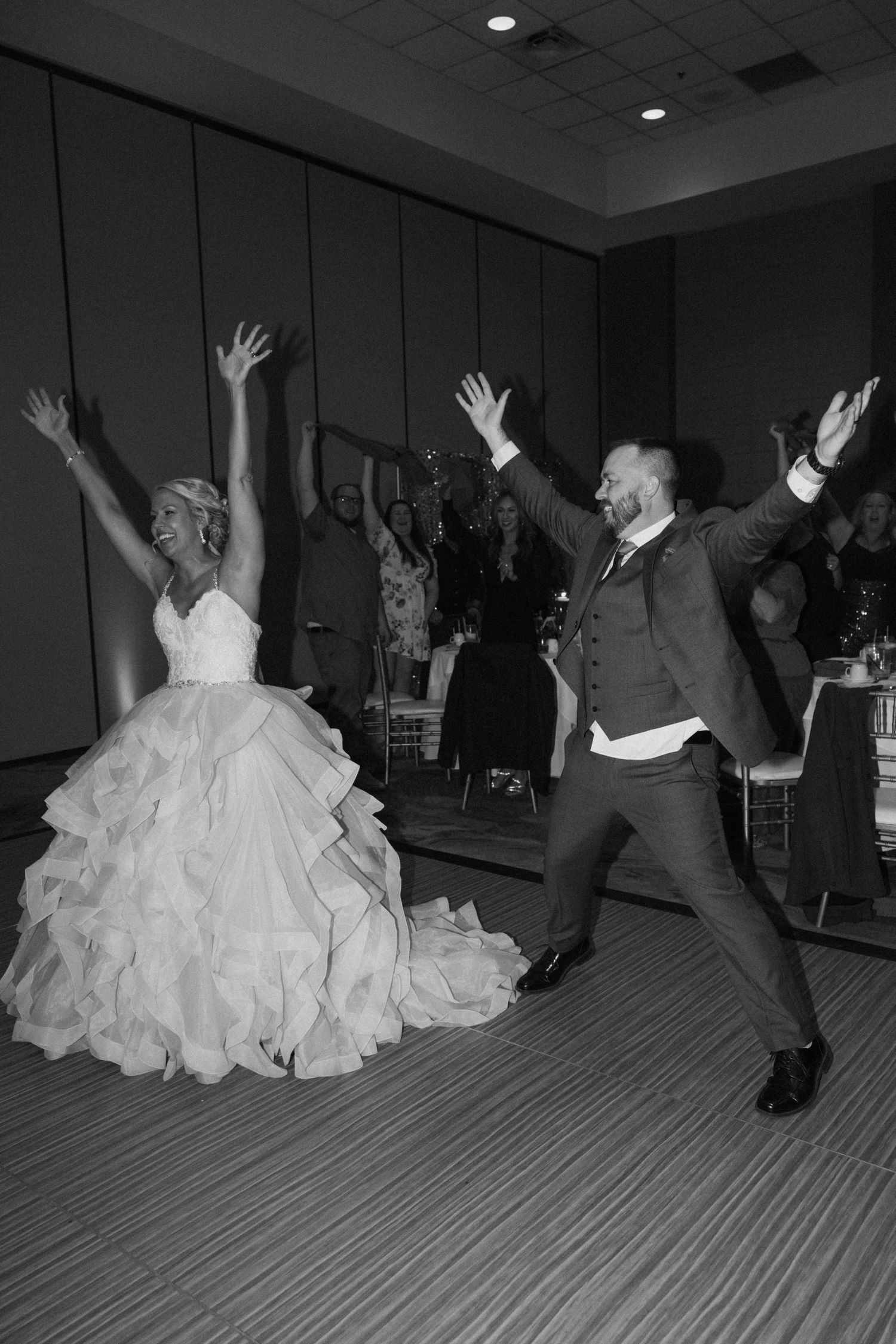 Black and white photo of wedding reception dancing with dramatic dress movement.