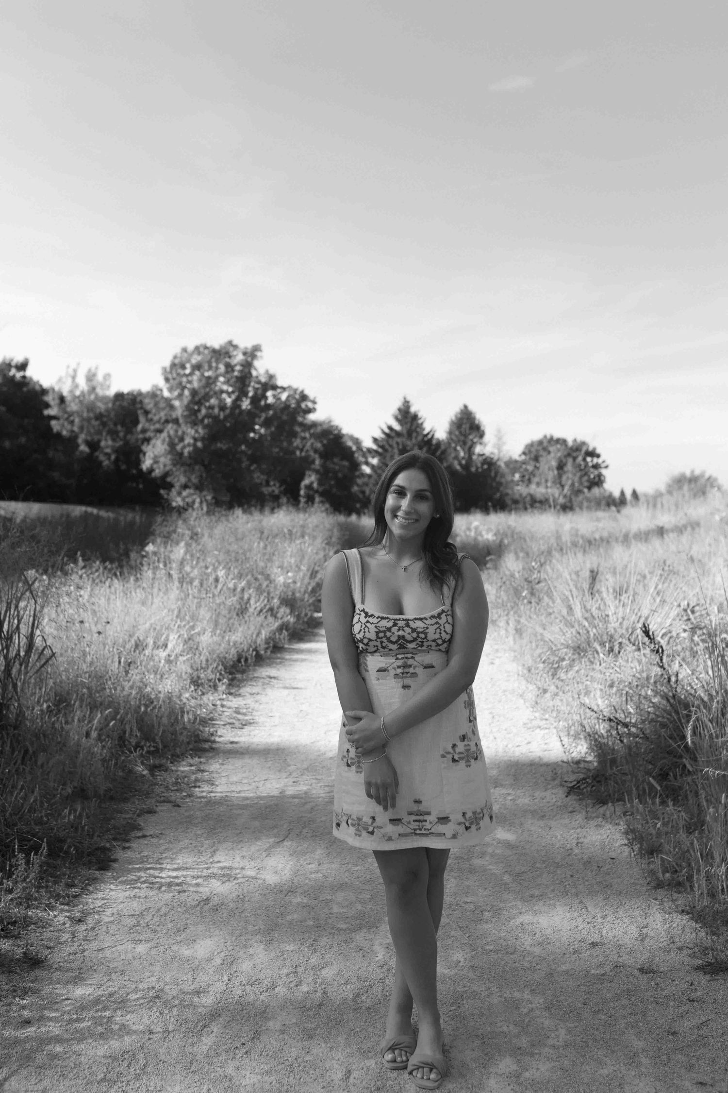 Black and white portrait on a winding path through tall summer grasses.