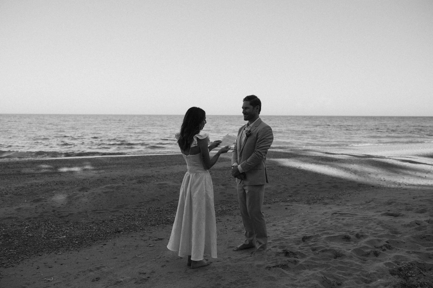 Black and white photos of a couple walking along a misty beach shoreline.