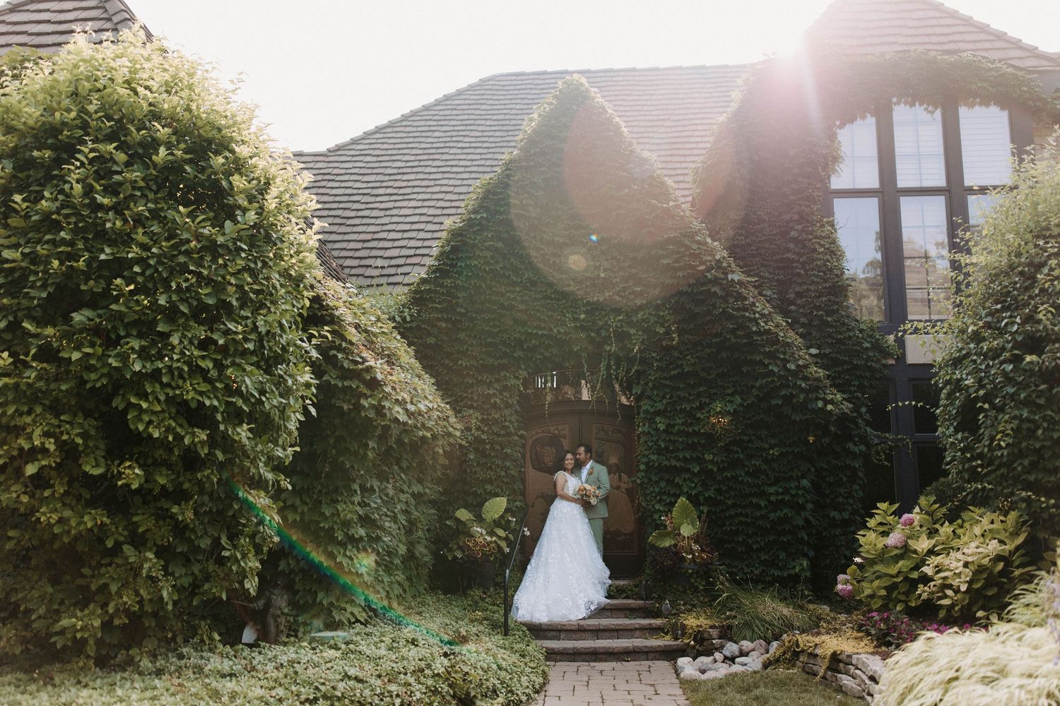 Sunset wedding photos taken outside a house with dramatic golden hour lighting.