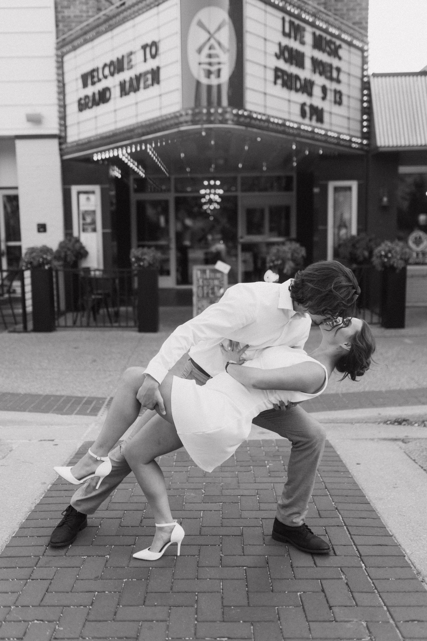 Playful dance dip sequence in front of a vintage theater marquee.