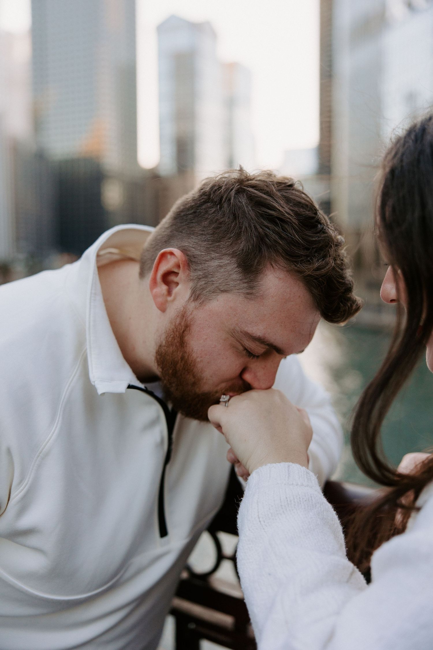 A tender moment between a couple with Chicago's skyline visible in the background.