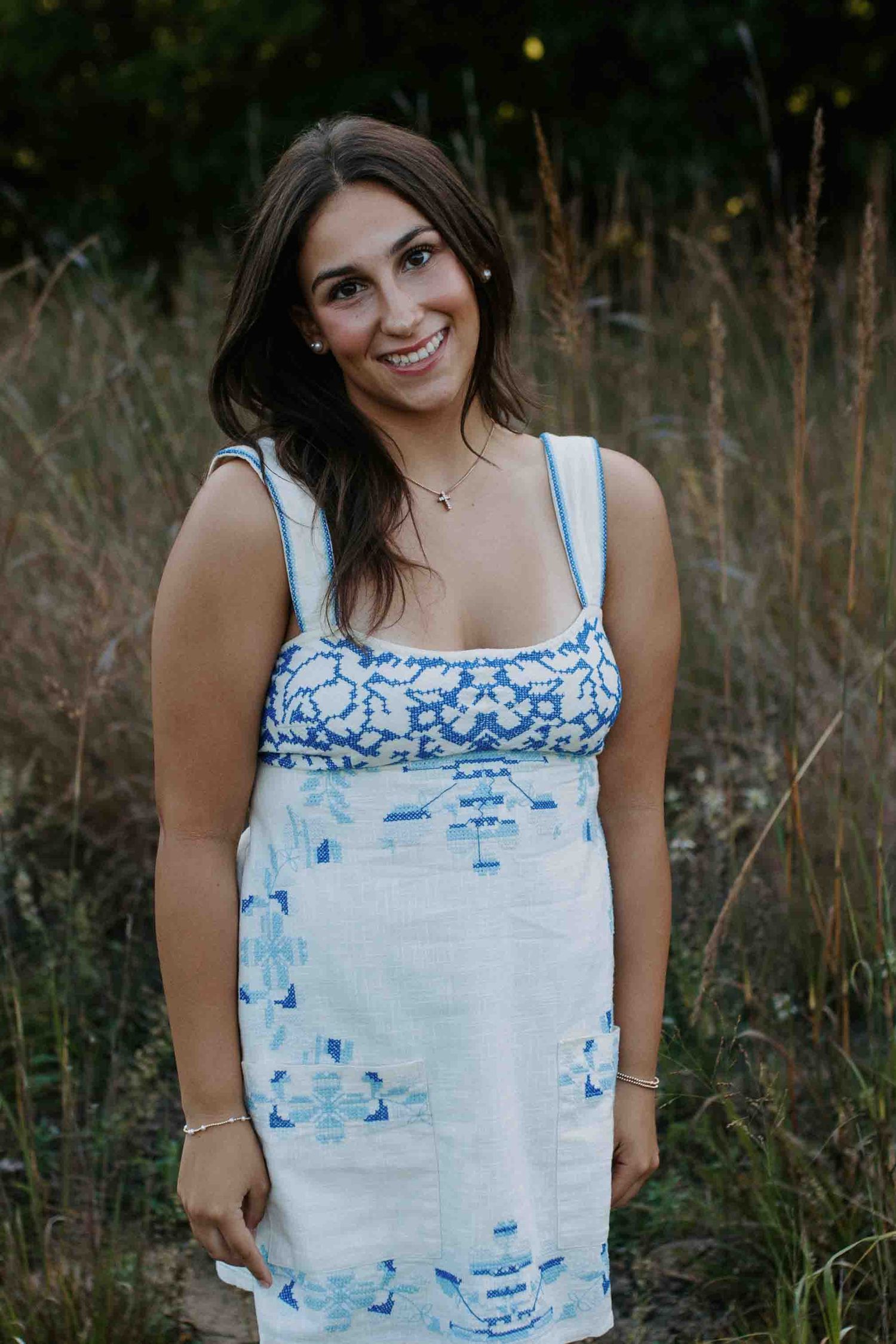 Summer fashion photography showcasing a white tank dress with blue pattern detail.