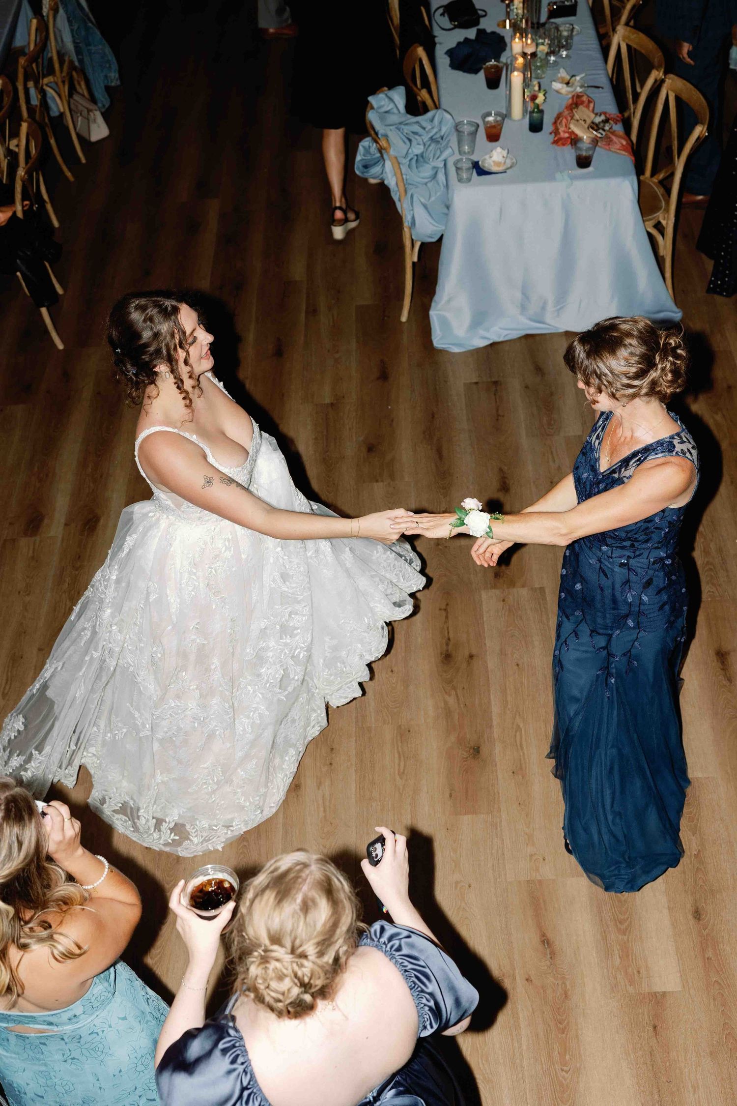 A bride in a white dress twirling and dancing at her wedding reception.