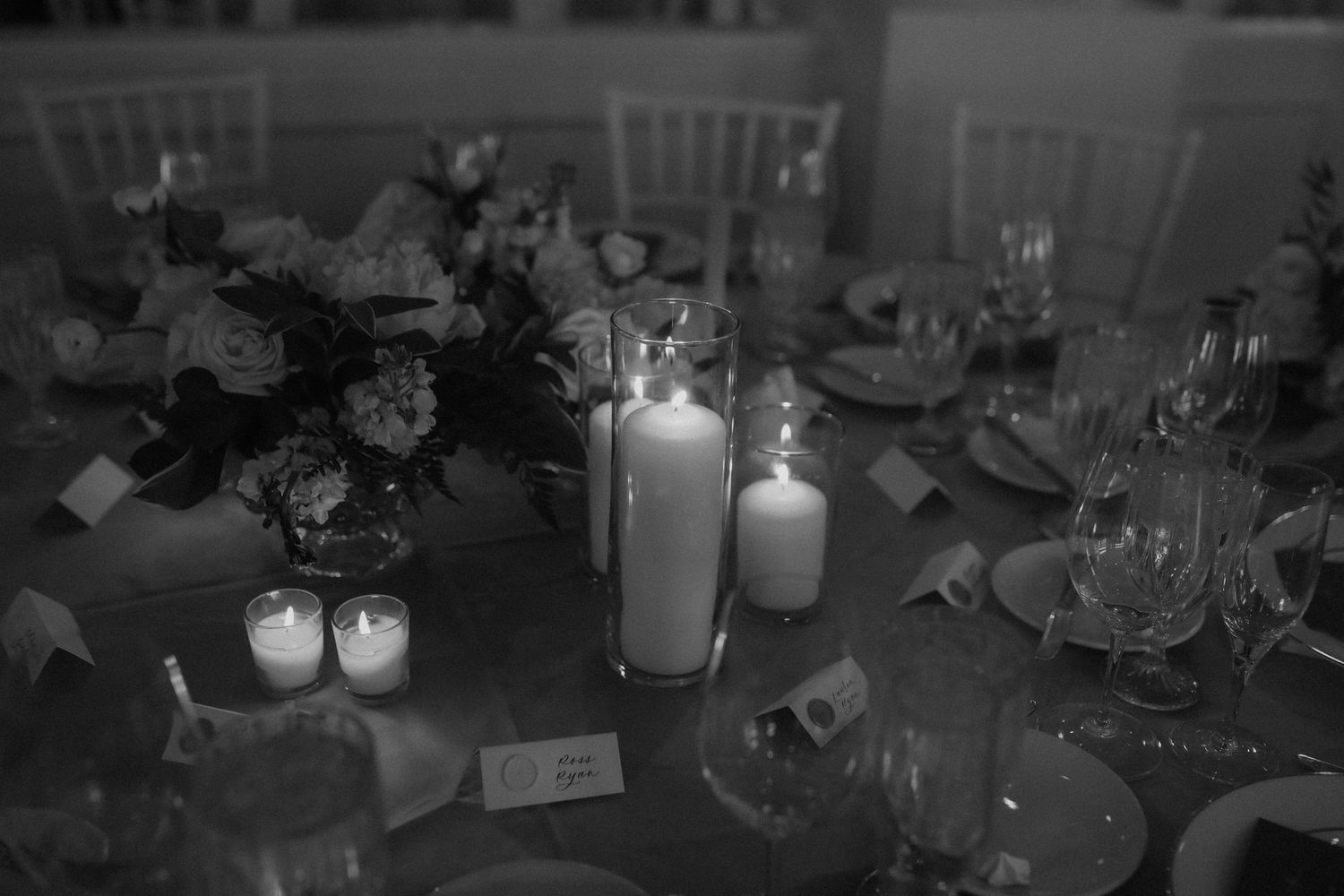 Dark reception venue illuminated by soft candlelight and ambient lighting.