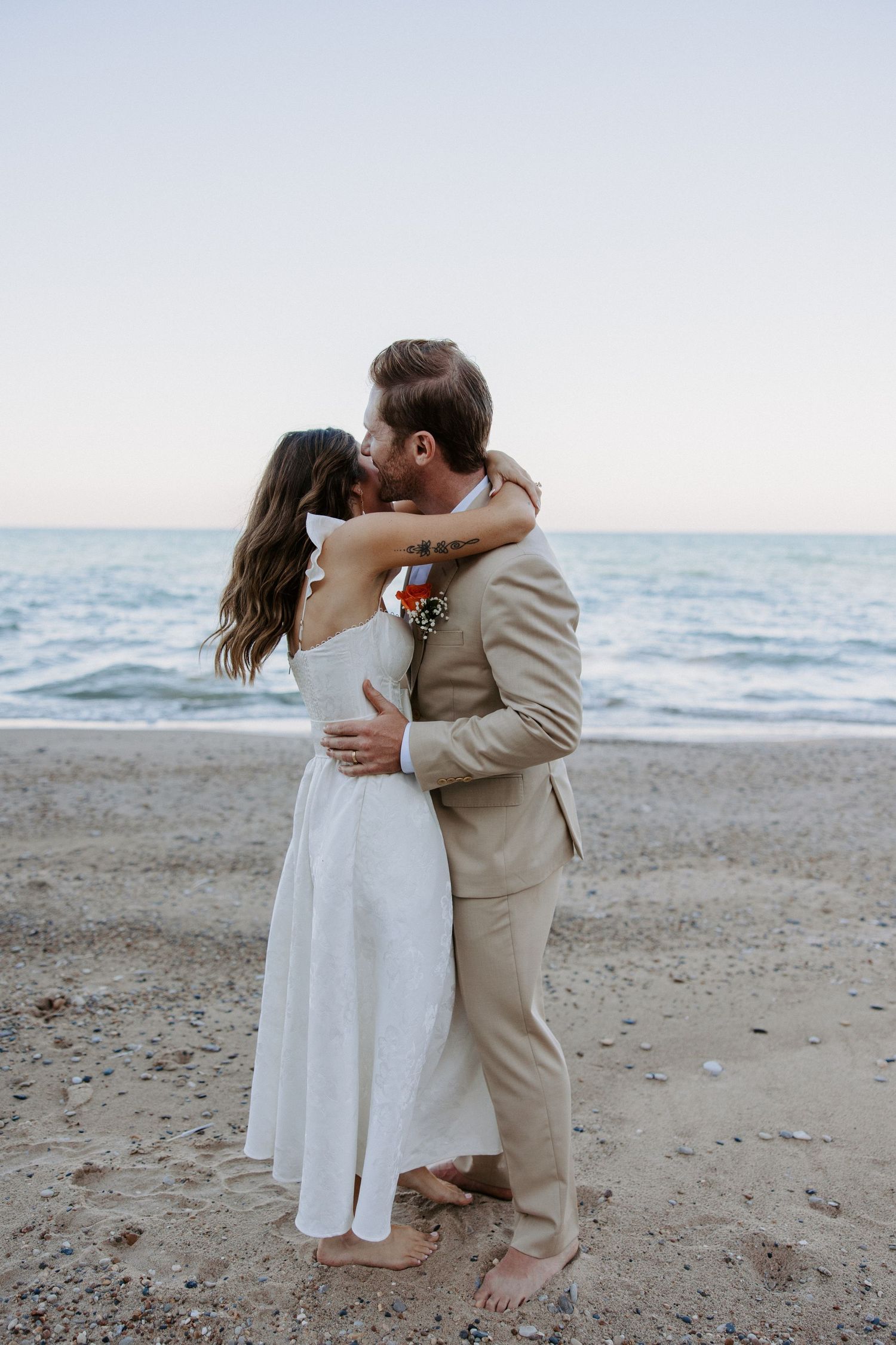 Romantic beach wedding portraits with waves and horizon in the background.