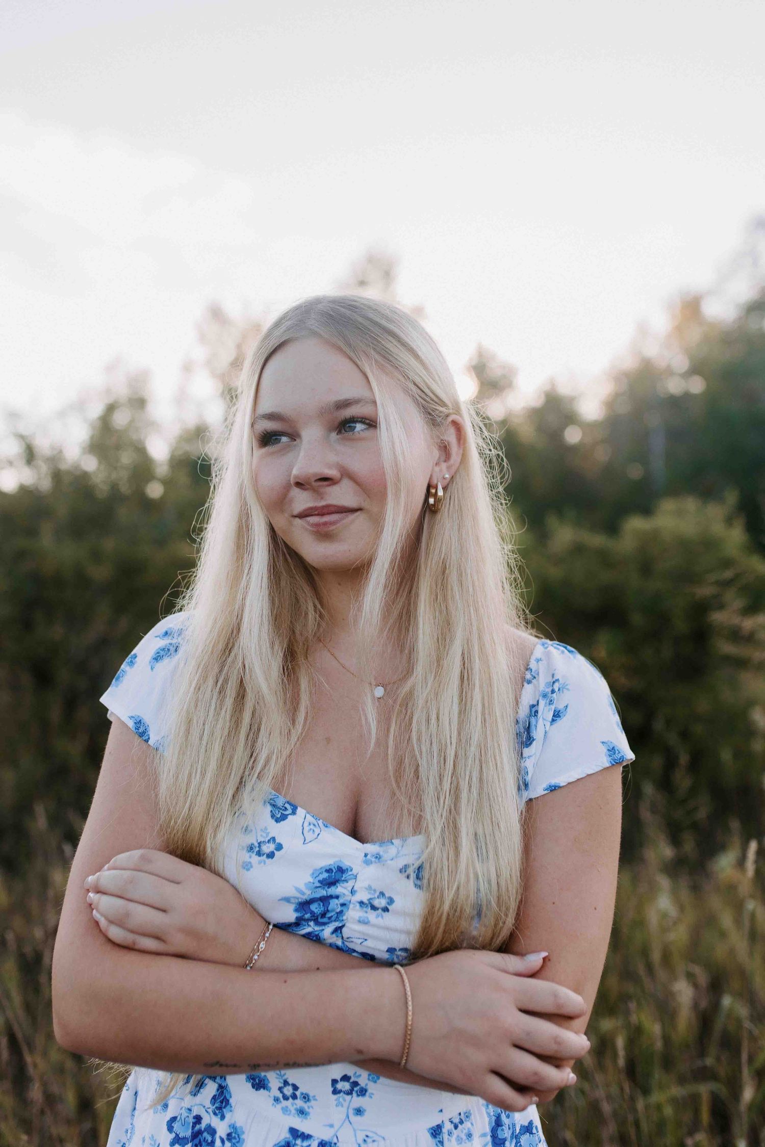 Close-up outdoor portrait with natural lighting and a blue floral summer dress.