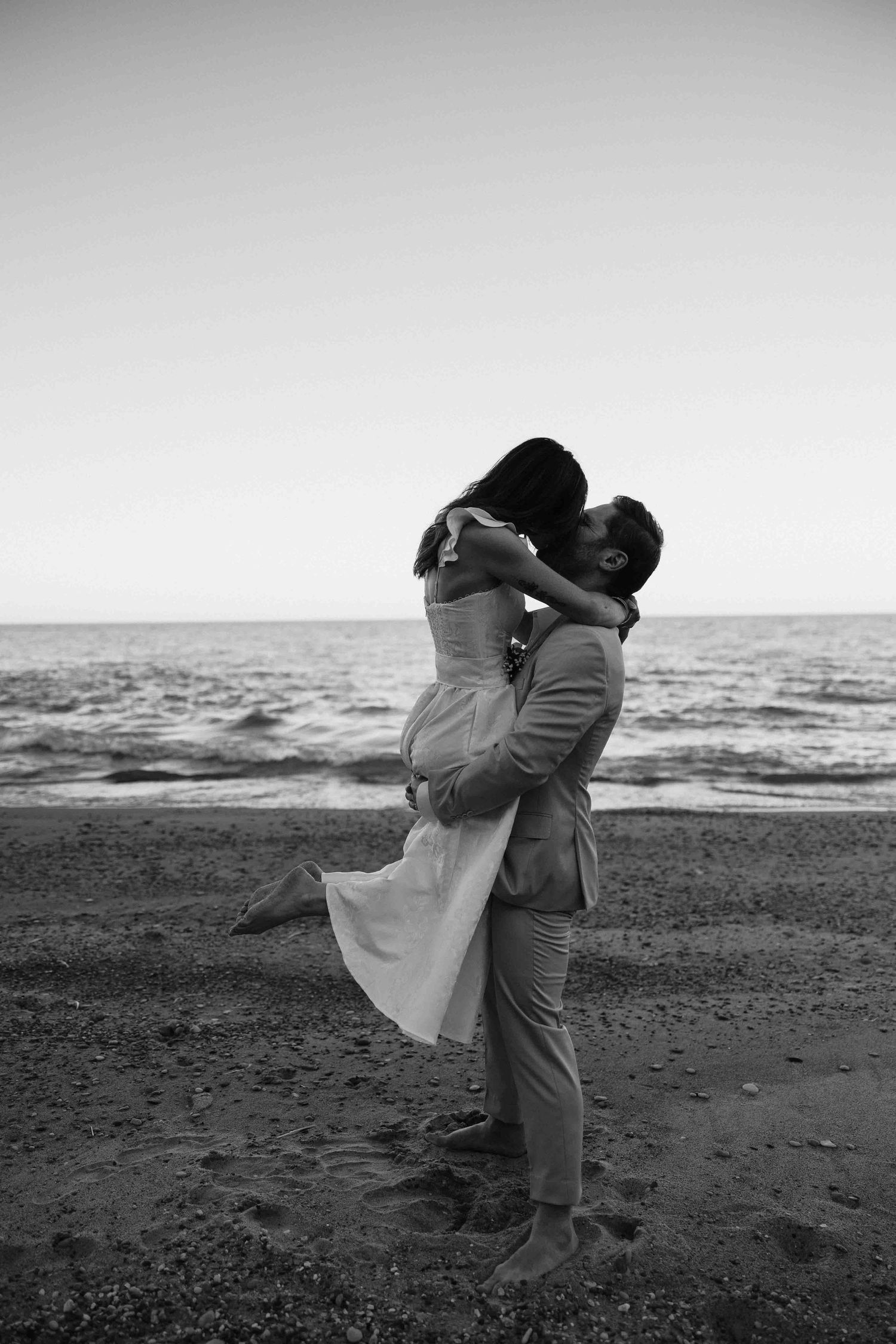 Black and white photos of romantic moments on a beach at sunset.