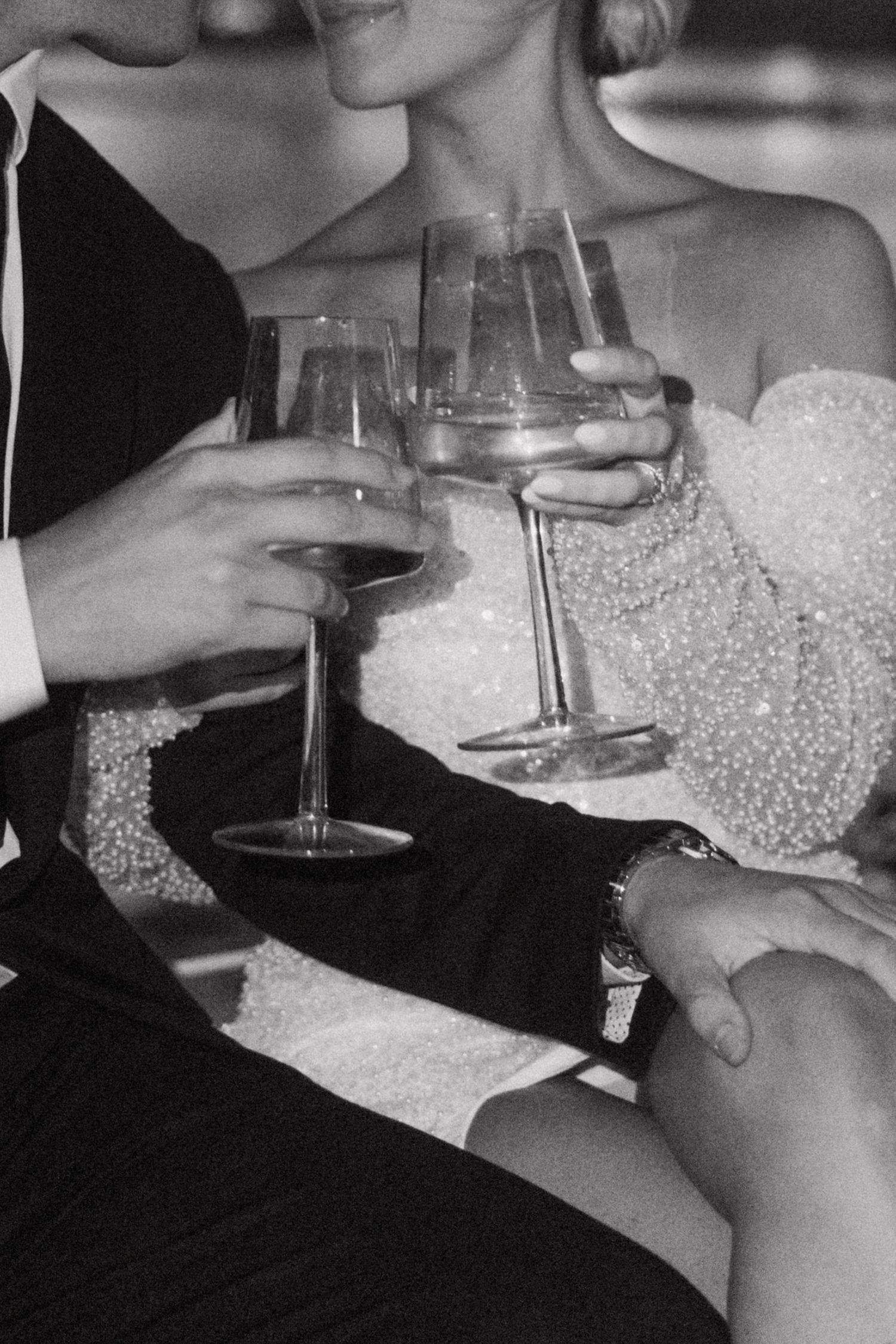 Close-up of hands holding wine glasses during a celebratory toast.