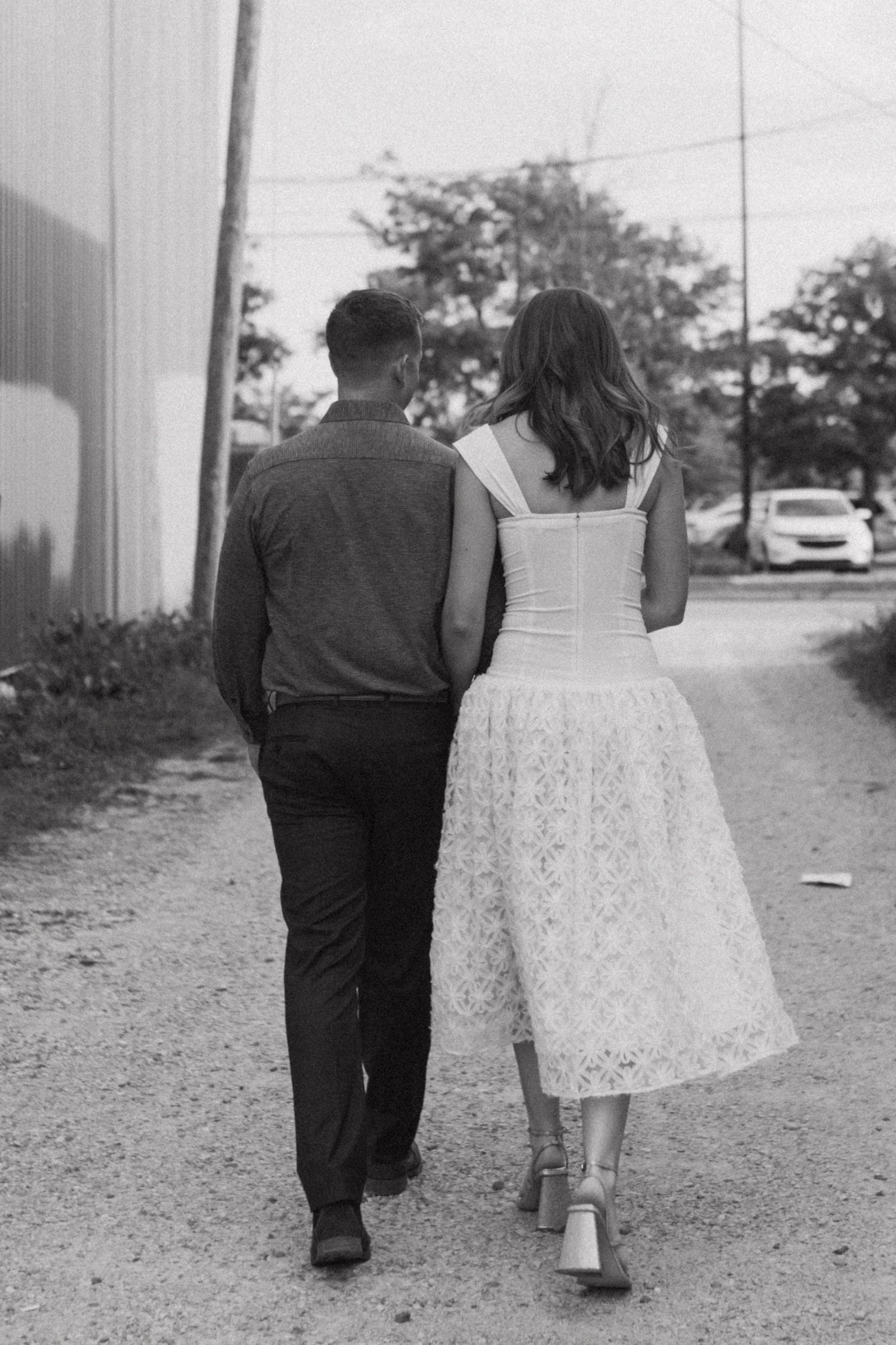 Black and white photo of couple walking together on a path.