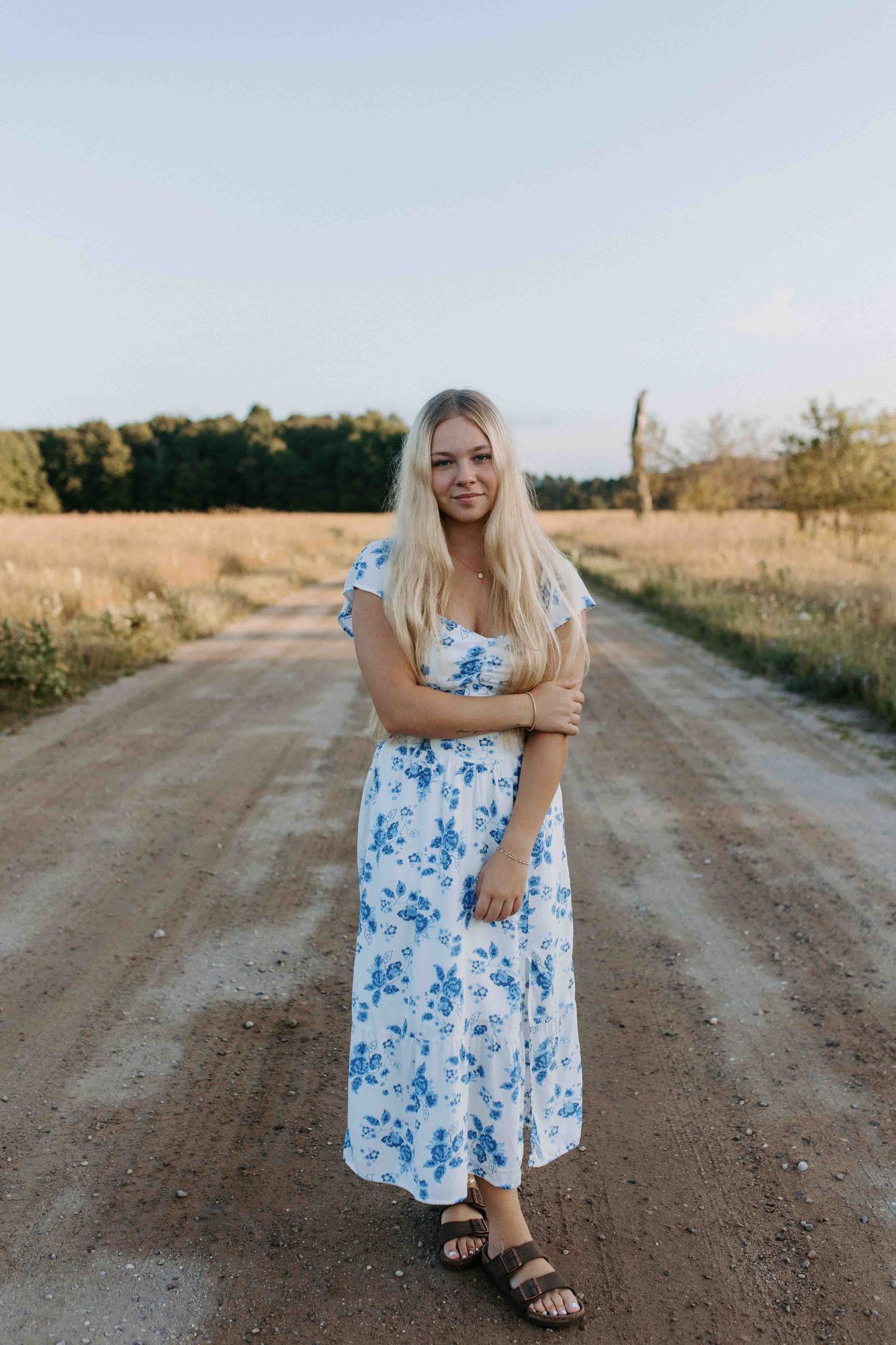 Playful poses on a dirt country road in a blue floral dress.