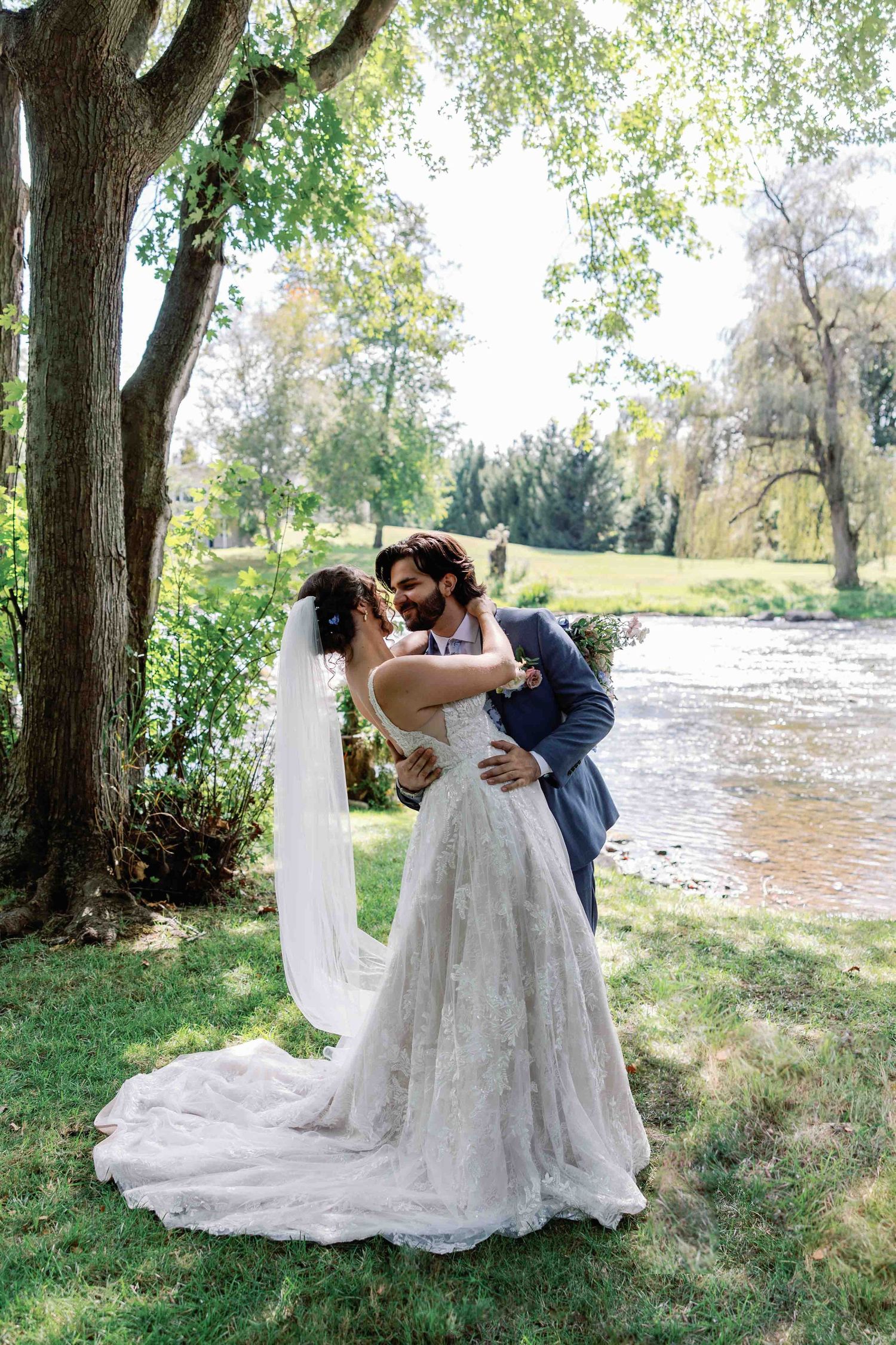 A romantic wedding photoshoot in a scenic outdoor location with flowing white dress details.